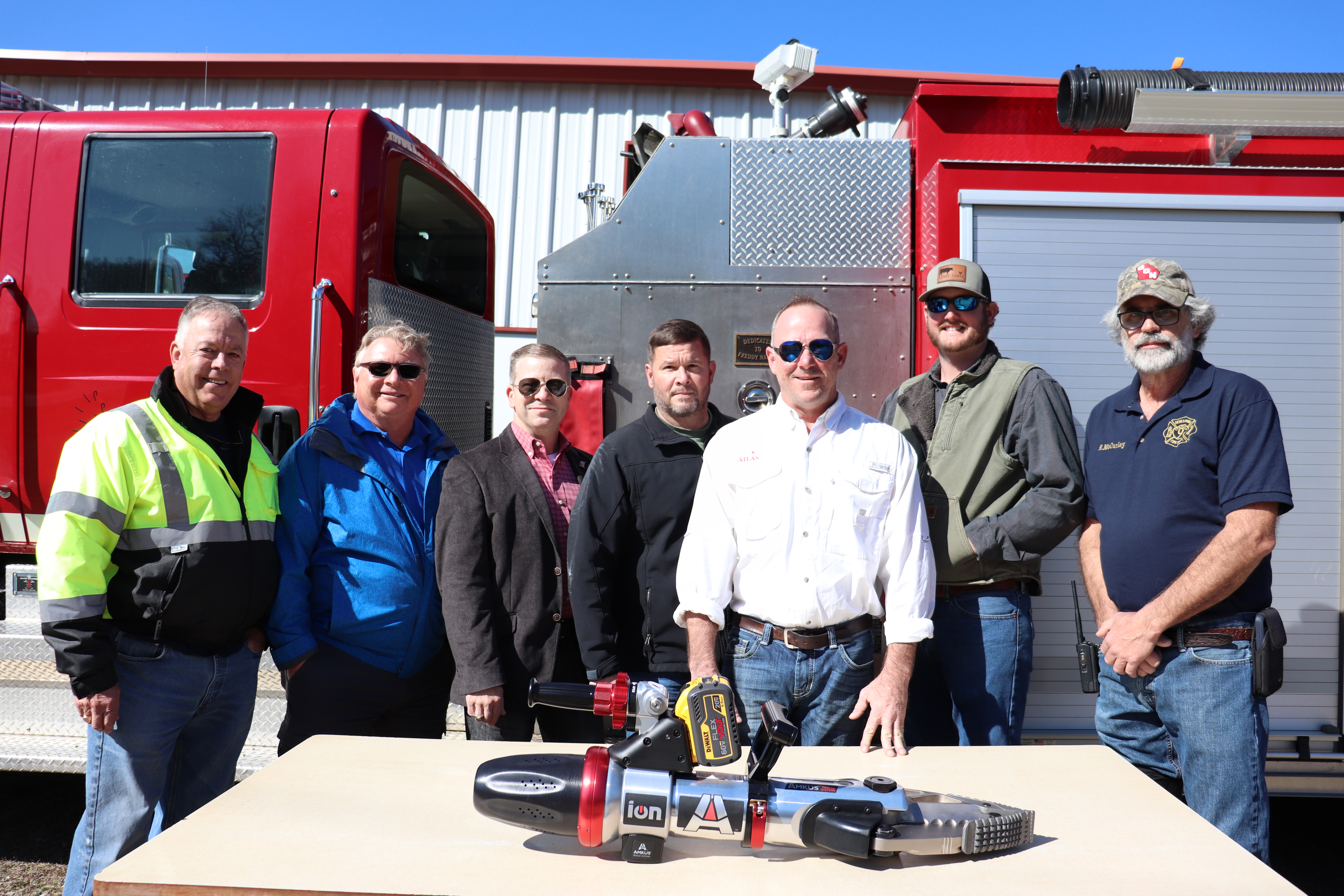 (Eloise Mcnair/Oglethorpe Echo) Devil’s Pond assistant fire chief Rocky Miller (from left), Rick Skoglund,  Commissioner Tracy Norman, Frank Moore, Jay Filipiak, T.J. Lowe and  Robby McCurley pose in front of the JAWS Combi Tool they helped  purchase for the Devil’s Pond Fire Department. 