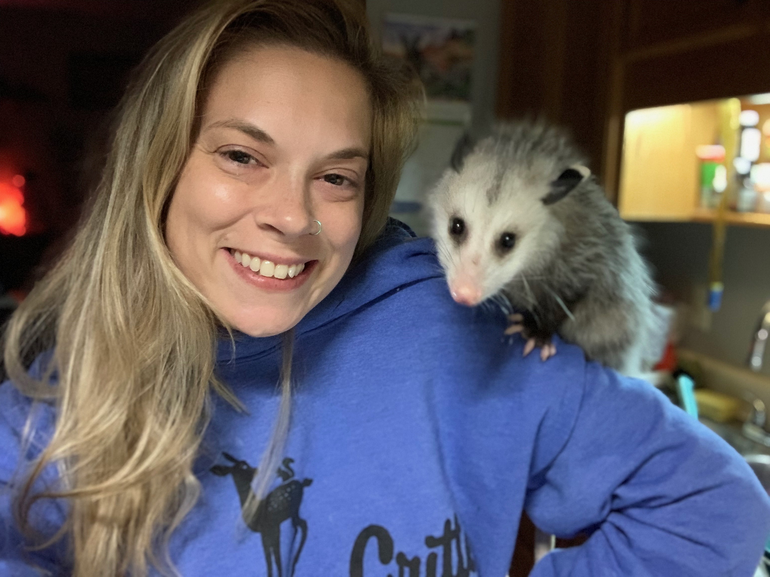 Nikki Hughes, founder of Camp Critter Wildlife Rescue, receives a visit from Persephone the Possum. Persephone  was a non-release case and now is the ambassador possum at Chattahoochee Nature Center in Roswell. (Submitted Photo)