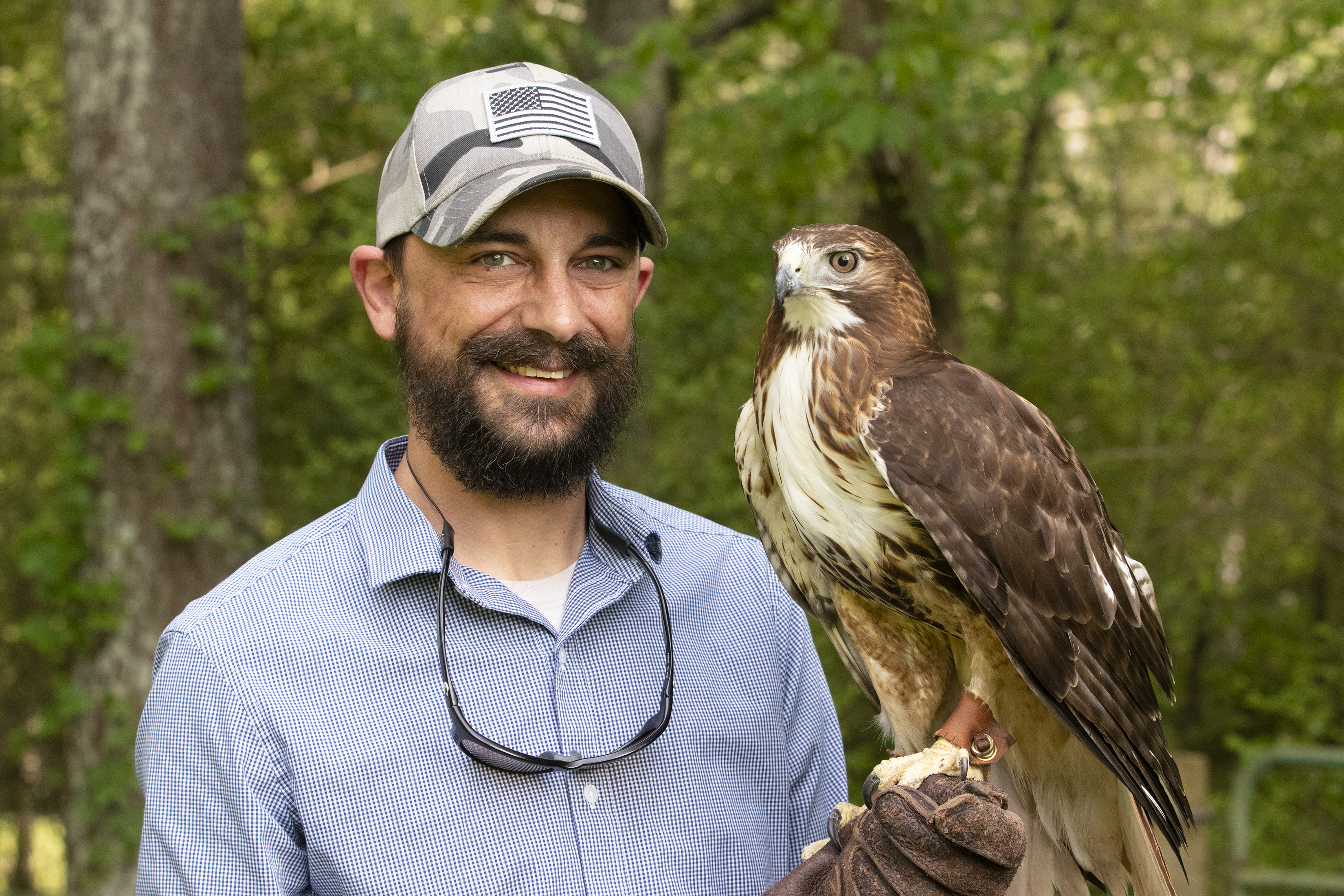 Ben Hill, a falconer who lives in Arnoldsville, poses with his red-tailed hawk, Belle. Hill, who has been falconing for about seven years, hunts with Belle as a sport and an art. (Photo/Julia Walkup)