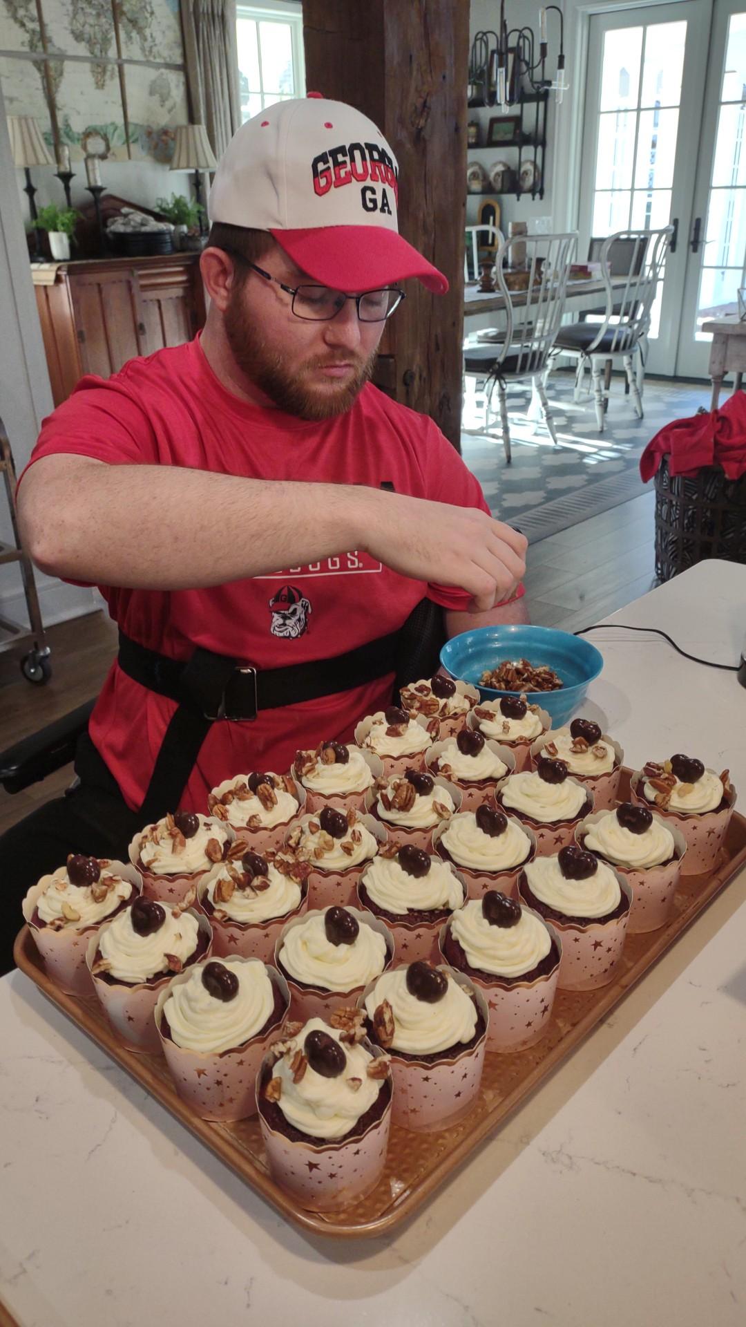 Dillon Lewis places chopped pecans on his chocolate pecan delight cupcakes. The Lewis family is proud of where D-Lo’s stands and doesn’t feel pressure to grow the business. (Submitted Photo)