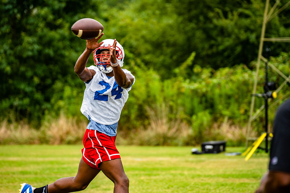 Tristan Anderson snags a pass during football practice this week as the Patriots prepare for their first game on Aug. 19. (Photo/Jack Casey)