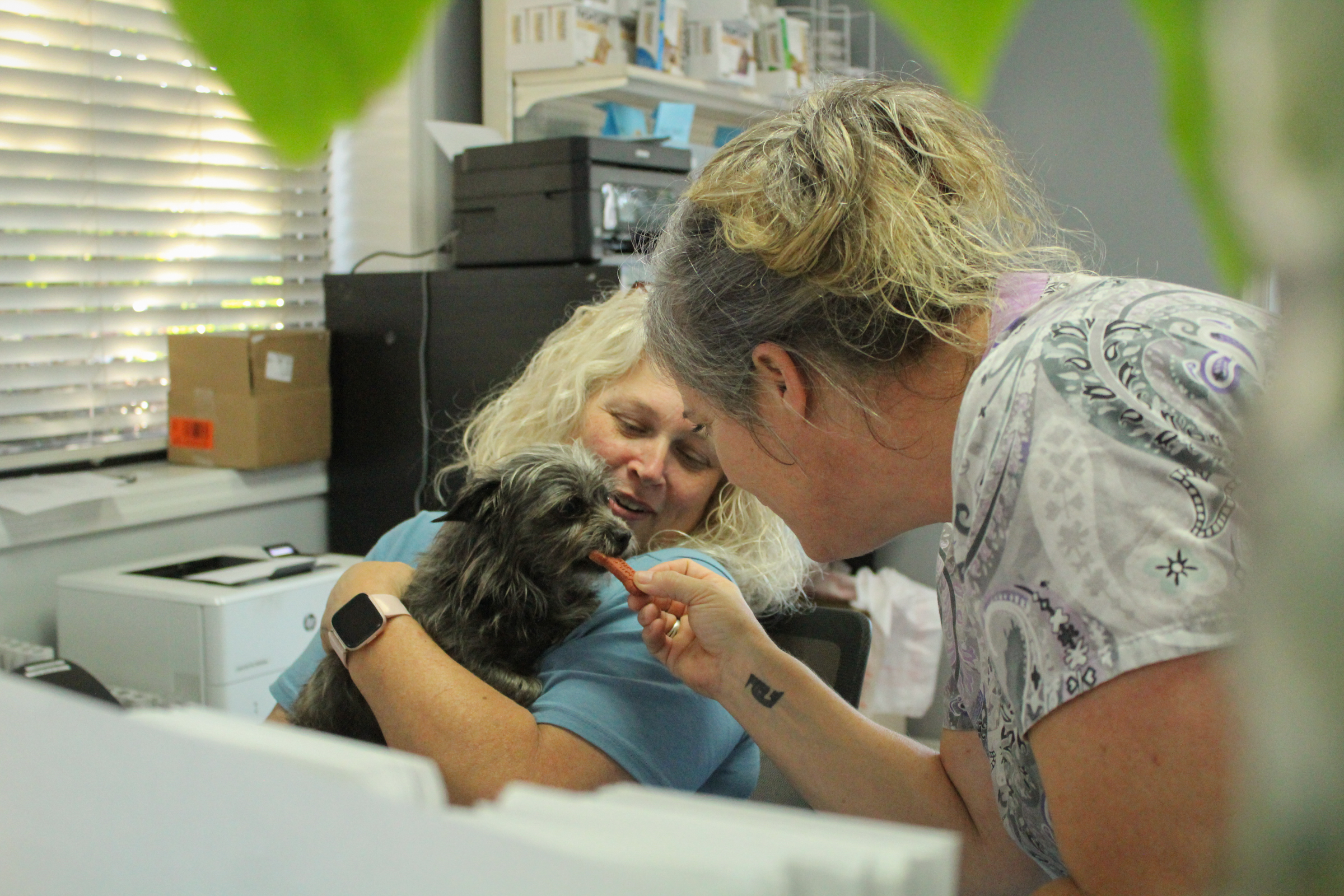 Oglethorpe Animal Clinic receptionists Karla Wallace, left, and Renee Evans, right, give TLC to a stray dog while waiting to re-house the animal earlier this month. (Basil Terhune/The Oglethorpe Echo)
