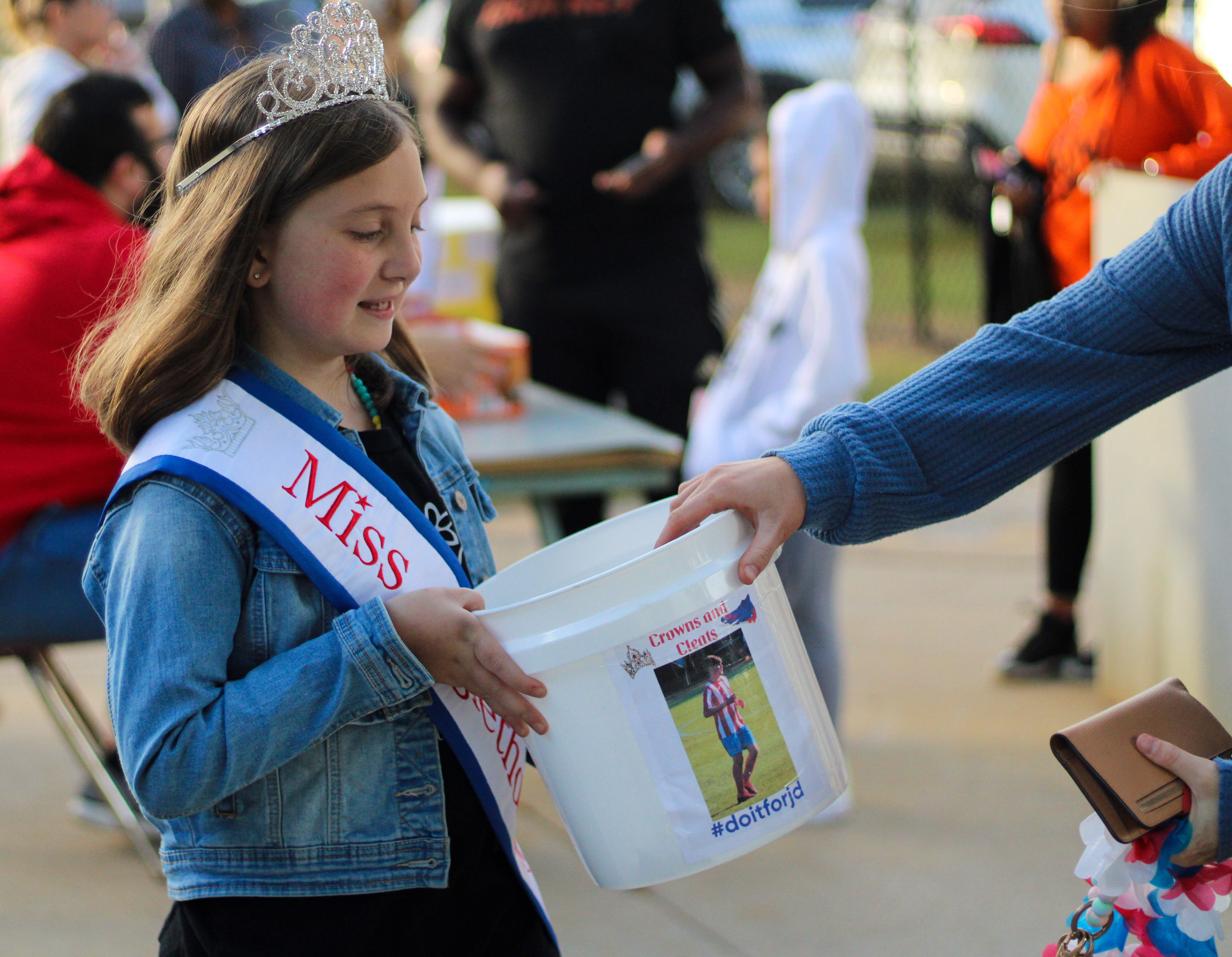 Miss Oglethorpe Princess Lilah Trejo, holds bucket for donations to support Jacob Dake, Oglethorpe County high school, Sept. 29, 2022. Dake was in a motorcycle accident on Sept. 15, and has had extensive surgeries since. (Aisha Shulz/The Oglethorpe Echo)