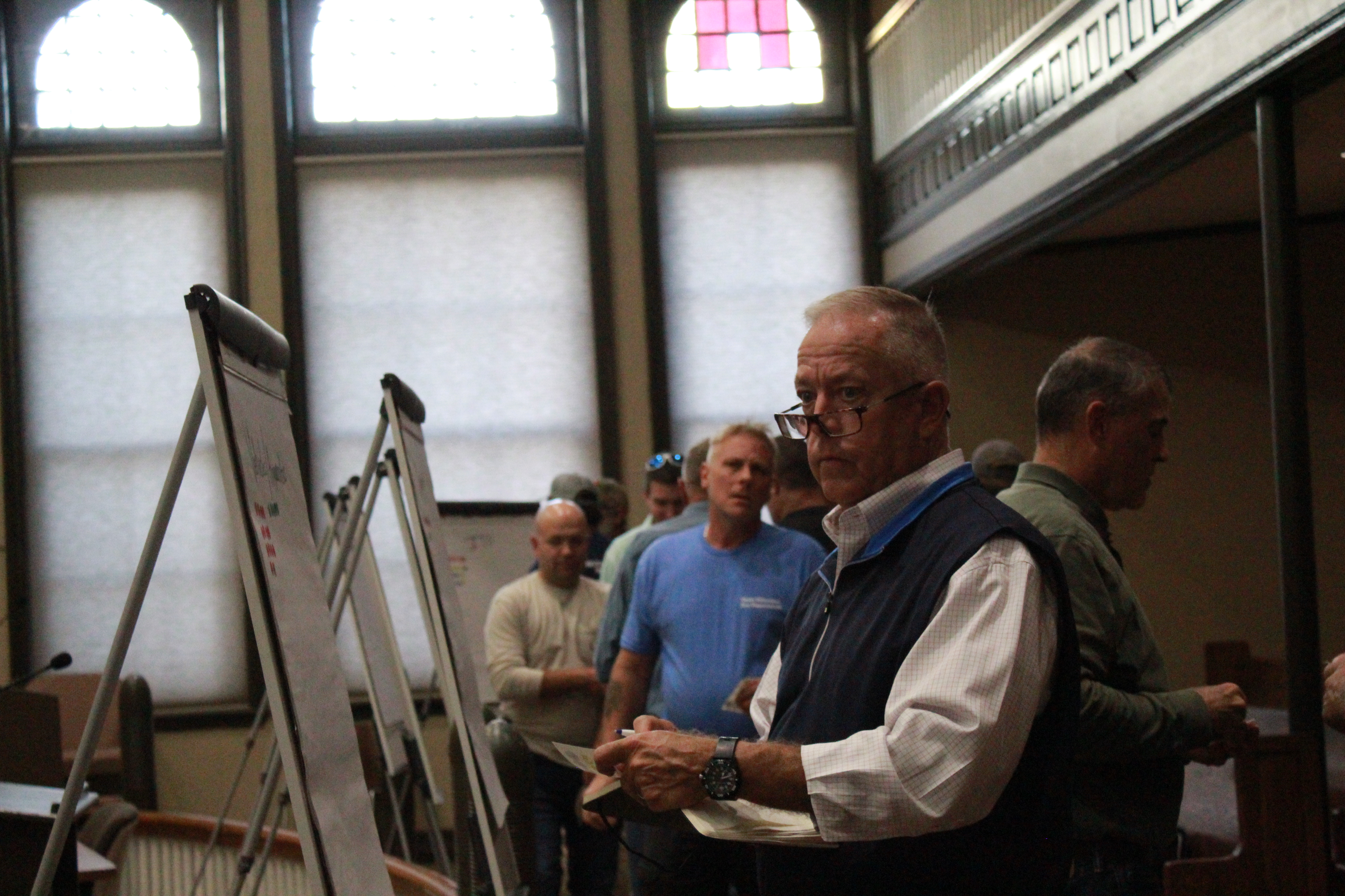 Firefighters place numbered stickers on large pads of paper to indicate their station's priorities during a meeting in the Oglethorpe County courthouse in Lexington, Georgia, on Monday, Oct. 17. (Emily Garcia/The Oglethorpe Echo)