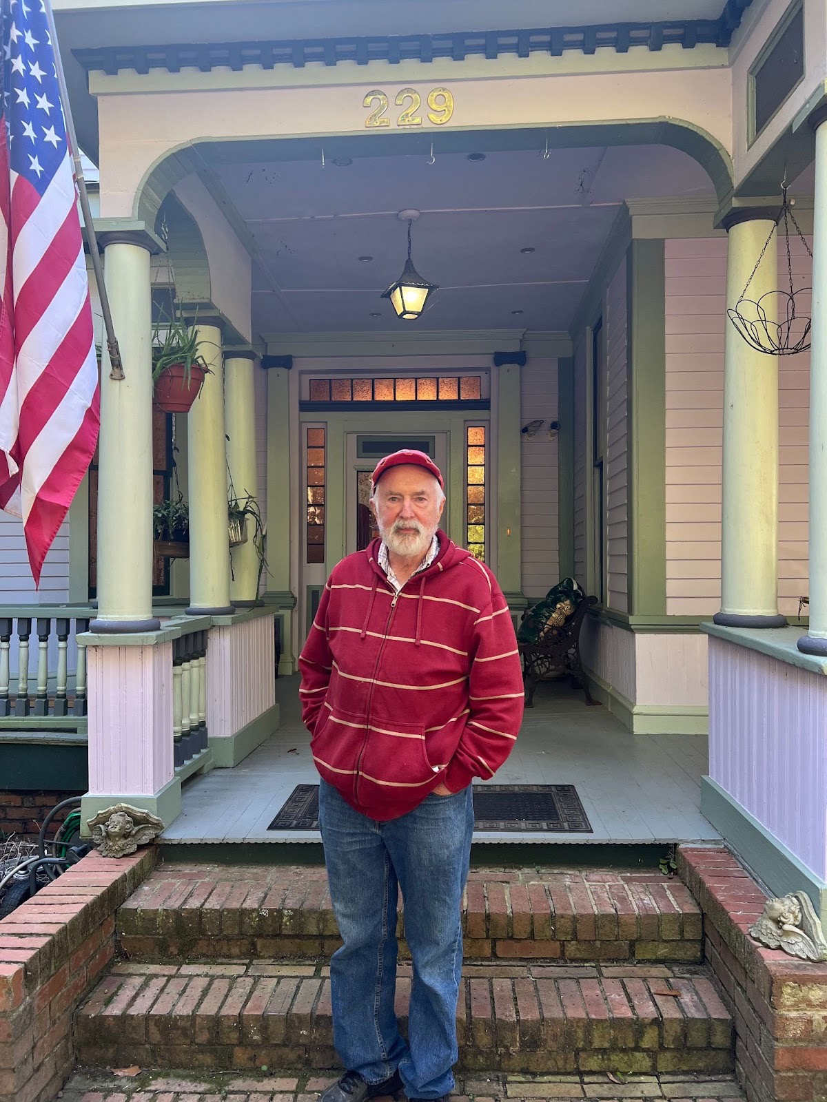 Tom Sheridan stands in front of the Crawford home he shares with his wife Sandra. They referred to a book called “Barber’s Turn-of-the-Century Houses” to help them restore the home like it might have looked more than 100 years ago. (PEYTON JENKINS/THE OGLETHORPE ECHO)