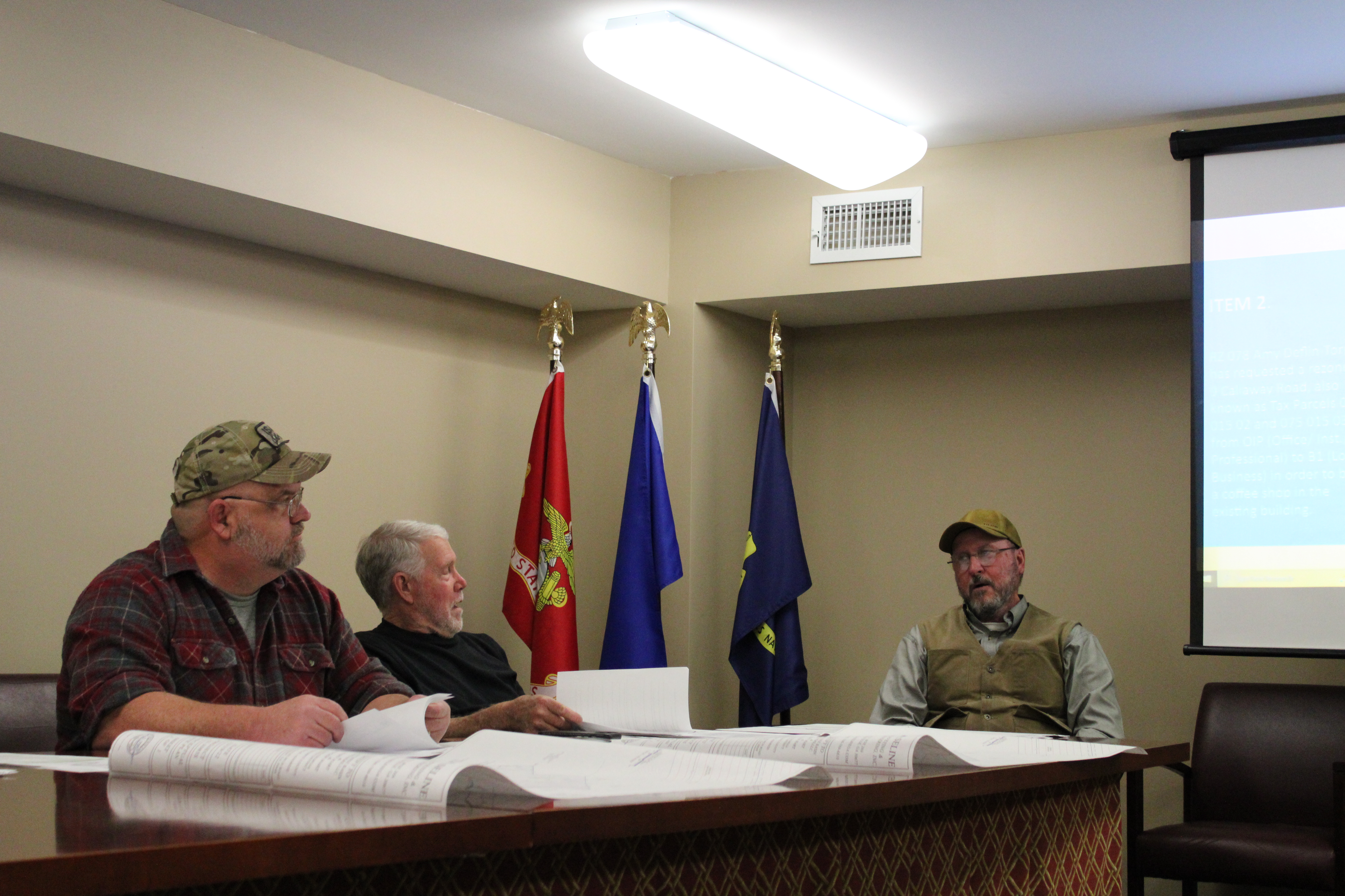 Oglethorpe County Zoning Board members Robert Drew (left)  and Jimmy Shealy discuss business with code compliance officer Jeff Sharp at the board meeting on Monday. The board approved a plan for a new coffee shop and a meat processing operation. (Photo/Sarah Donehoo)