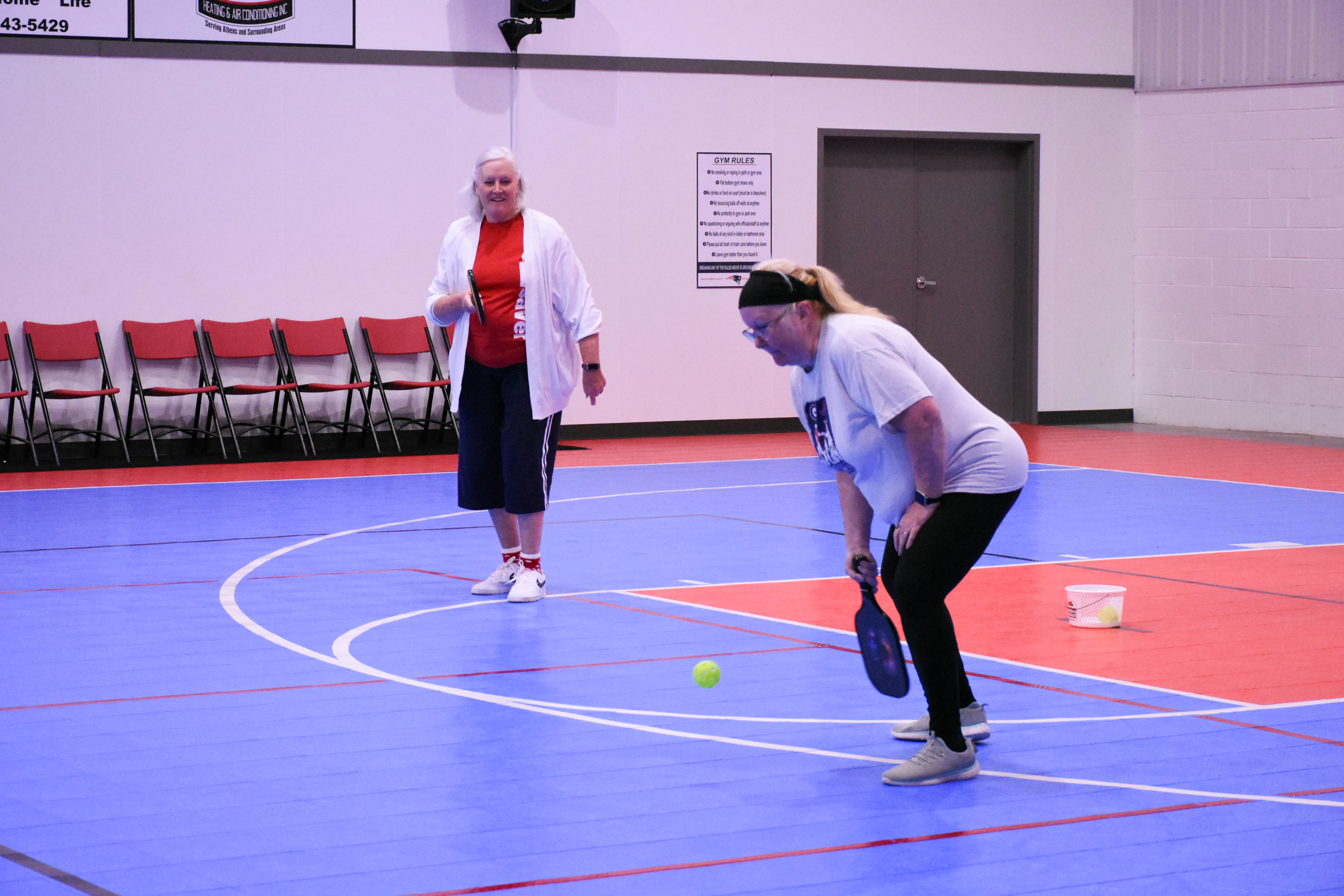 Crawford’s Karen Patman prepares to hit the ball as her partner Elaine McGarity, of Winterville, watches during a match at the Oglethorpe County Rec Center. They are two of a regular group of 16 players who play the fast-growing sport. (Photo/Molly Linder)