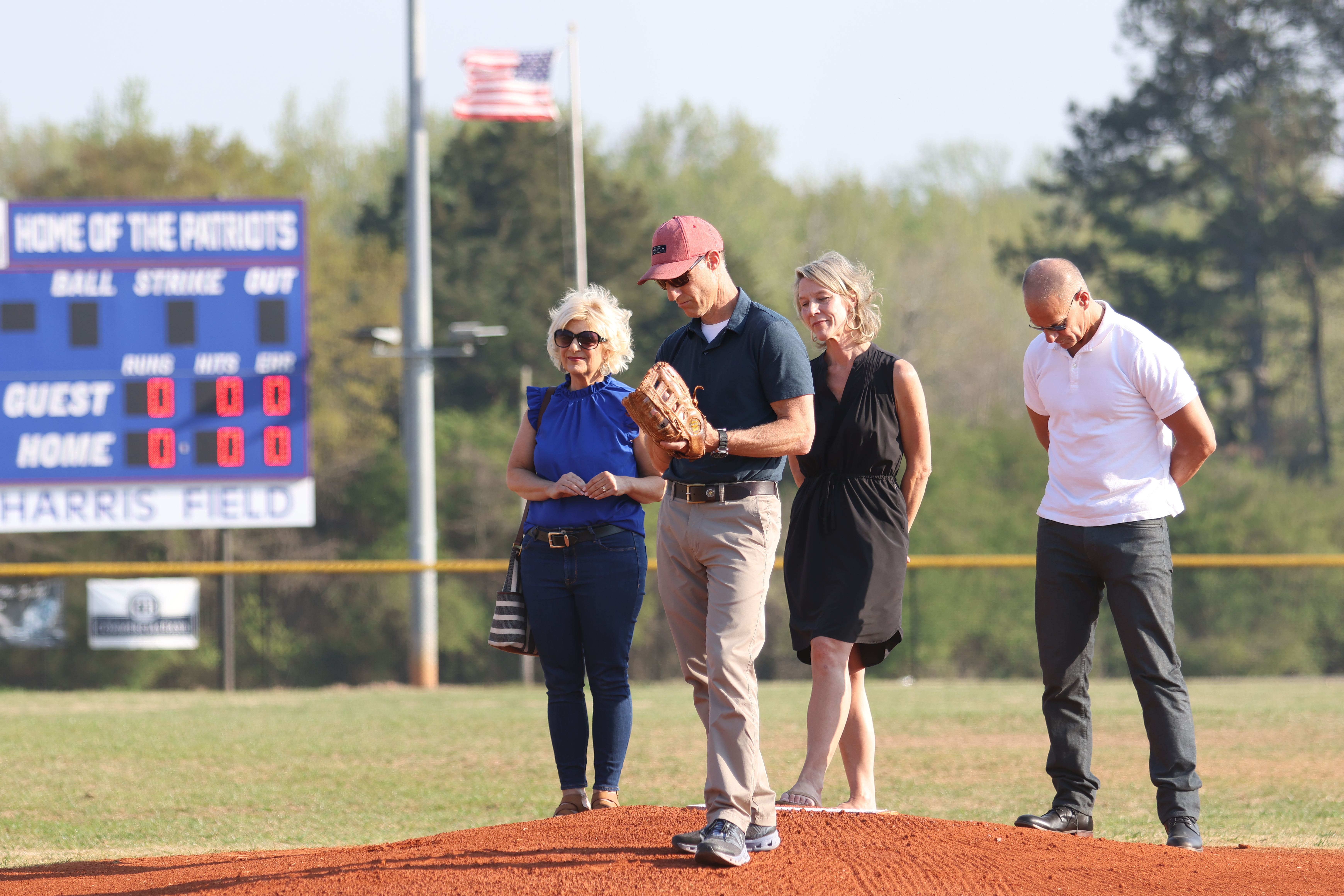 Steve Harris, a son of former school superintendent Thomas Young (TY) Harris, prepares to throw out the first pitch before Oglethorpe County’s baseball game on Friday, March 24. The school system named the OCHS baseball field in honor of Harris, who died in February, 2022. All four of his children (from left): Paige Colquitt, Steve Harris, Suzanne Mingledorff and Thomas Harris IV attended the dedication. (Emily Dozier/ The Oglethorpe Echo)