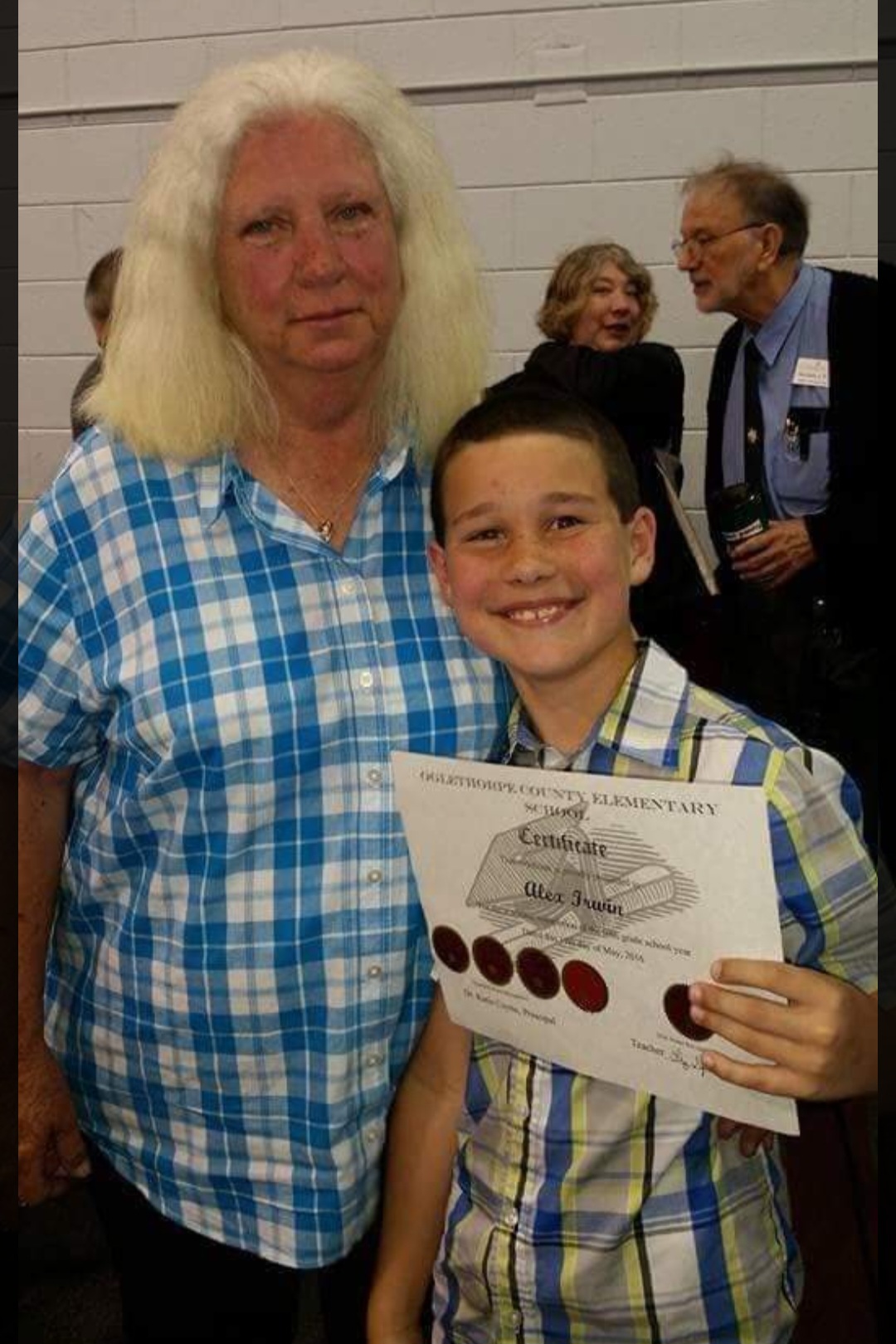 Alex Irwin poses with his grandmother Janice Messer at an OCES honors program several years ago. Irwin, who competes in jiu-jitsu, now raises money through Tap Cancer Out. (SUBMITTED PHOTO)