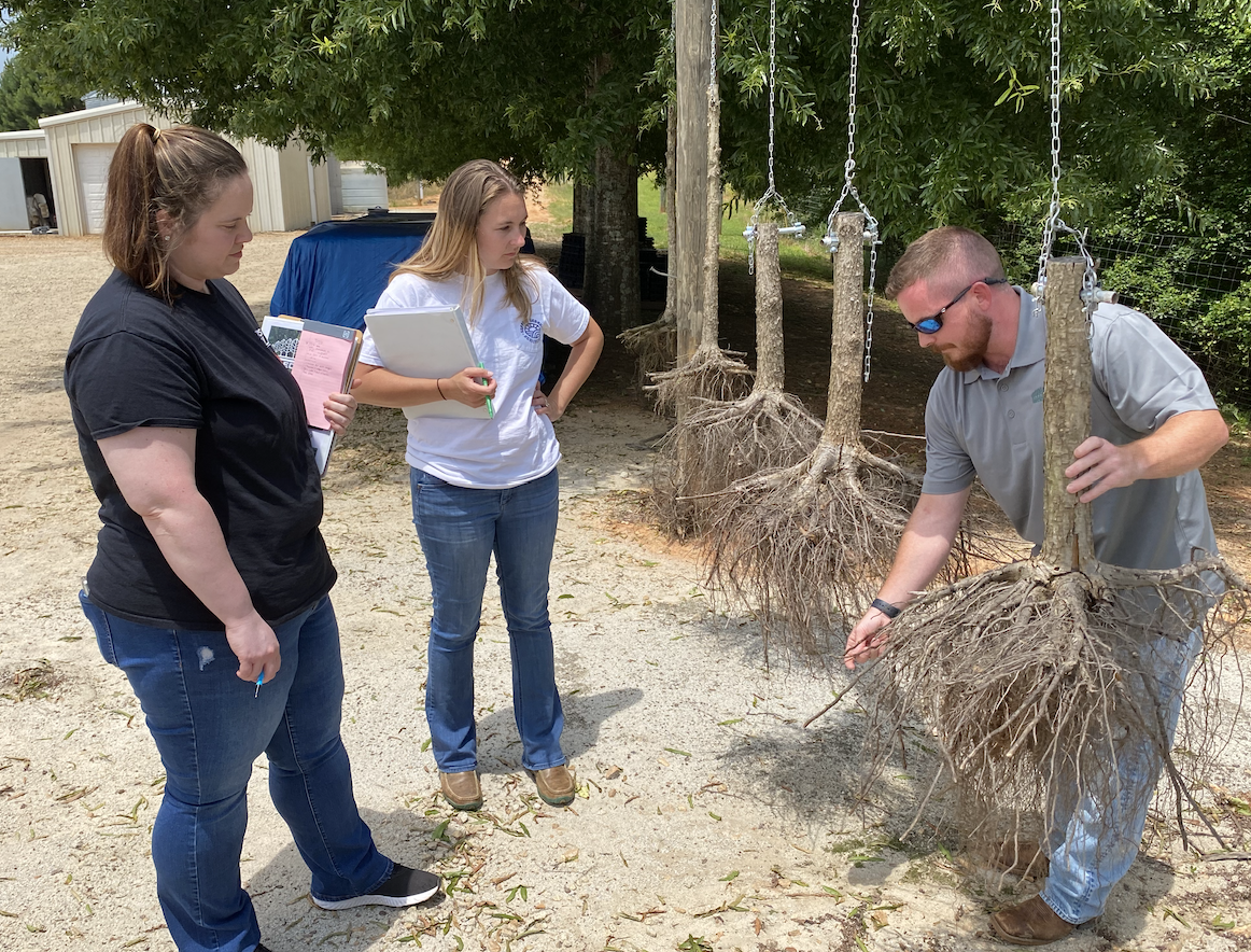 Josh Lee (right), business development manager for Select Trees, takes OCHS teachers Emily Williams ( left) and Kaitlyn Marchant on a tour of the facility as part of an externship through WorkSource NEGA.  (GARRETT KICKLIGHTER/THE OGLETHORPE ECHO)