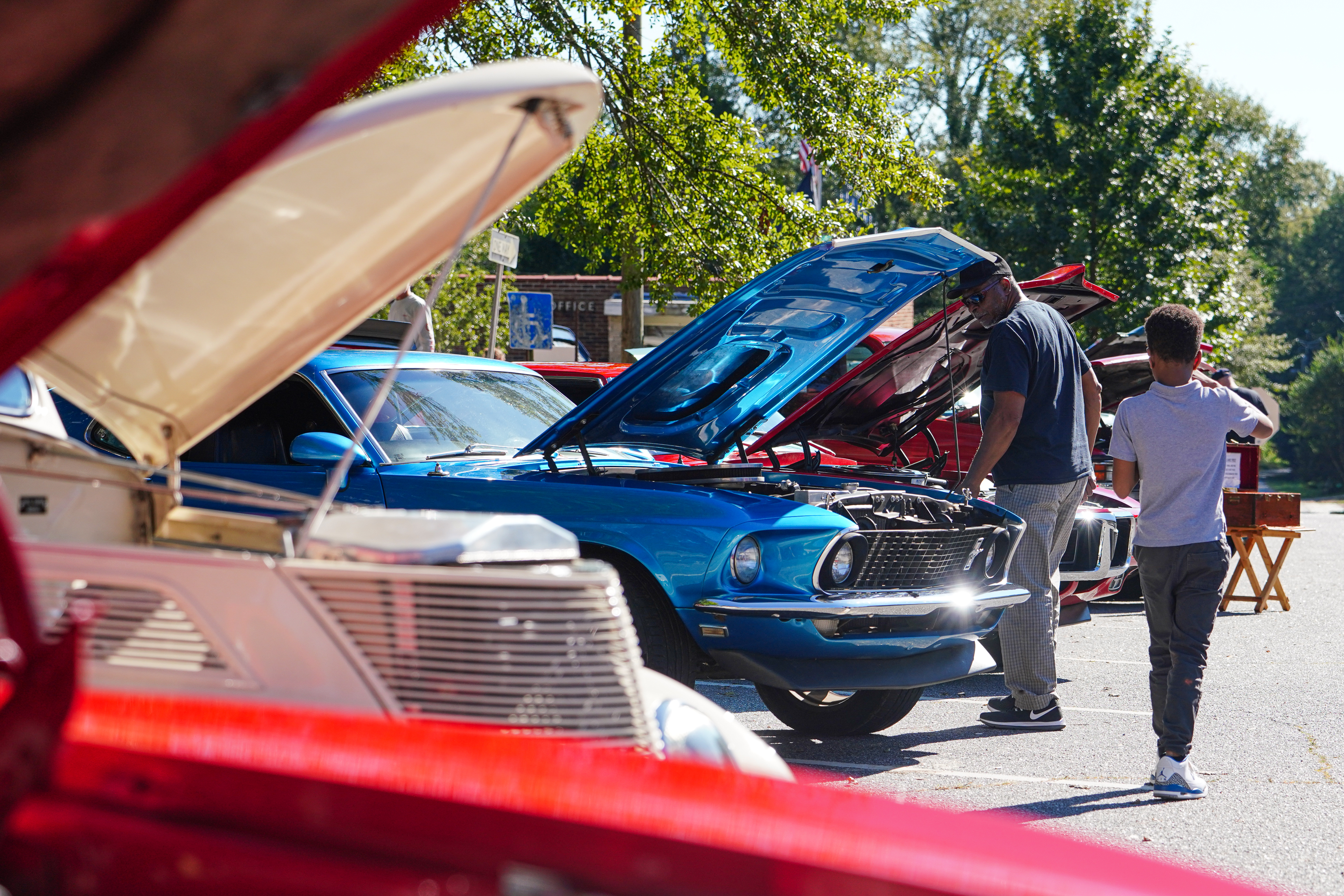 Visitors check out a vintage Mustang at the Firefly Cruise In last Sunday in Lexington. The event featured cars dating back as far as the 1930s. (Sidney Chansamone/The Oglethorpe Echo)