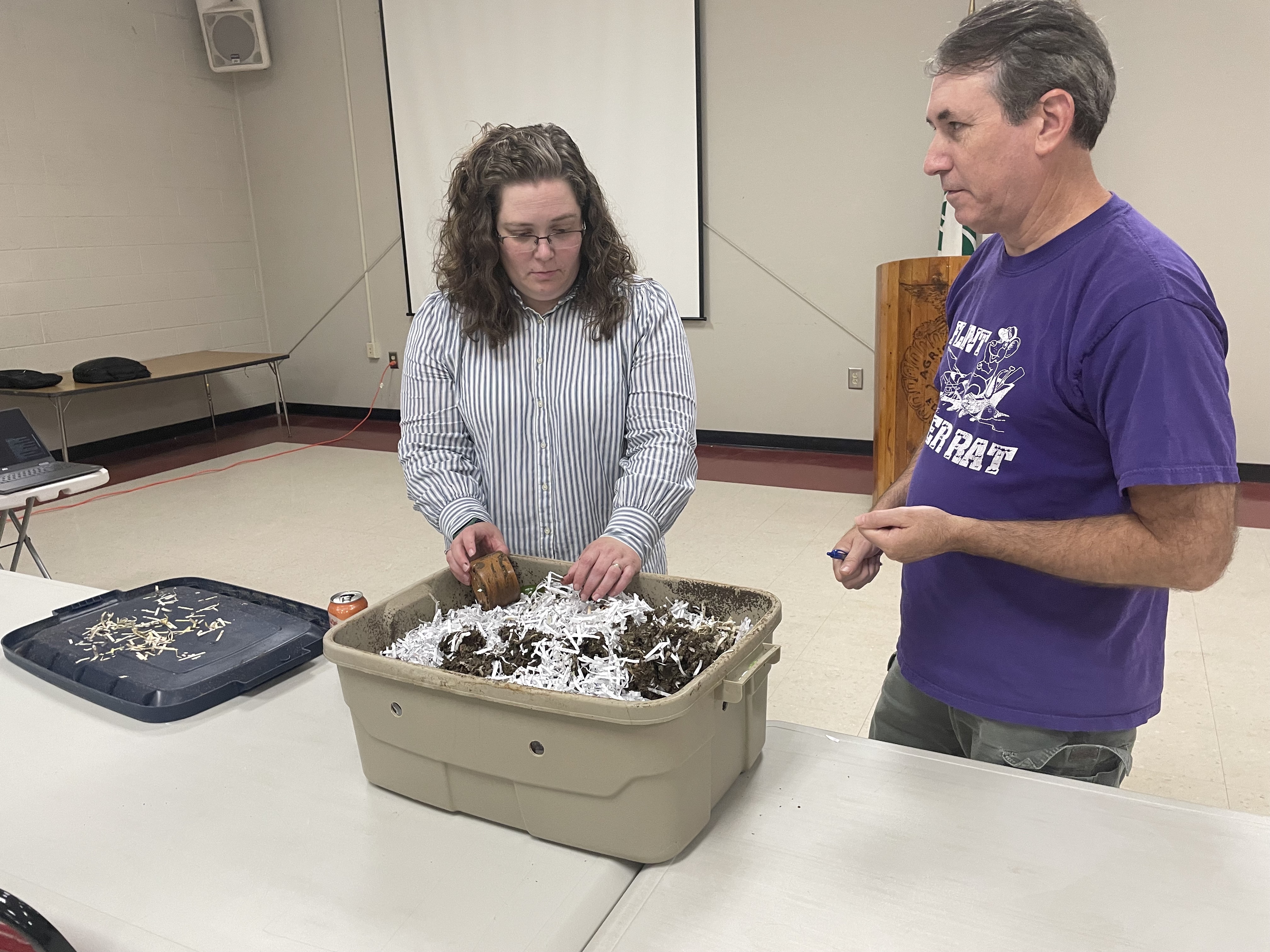 Amanda Tedrow and Patrick Phelps discuss Tedrow's compost bin, which includes dirt, paper scraps, vegetables and worms. She showed the box at the UGA Extension Office’s second annual Fall Garden Workshop in Lexington on Aug. 31. (Photo/John Henry Hammond)