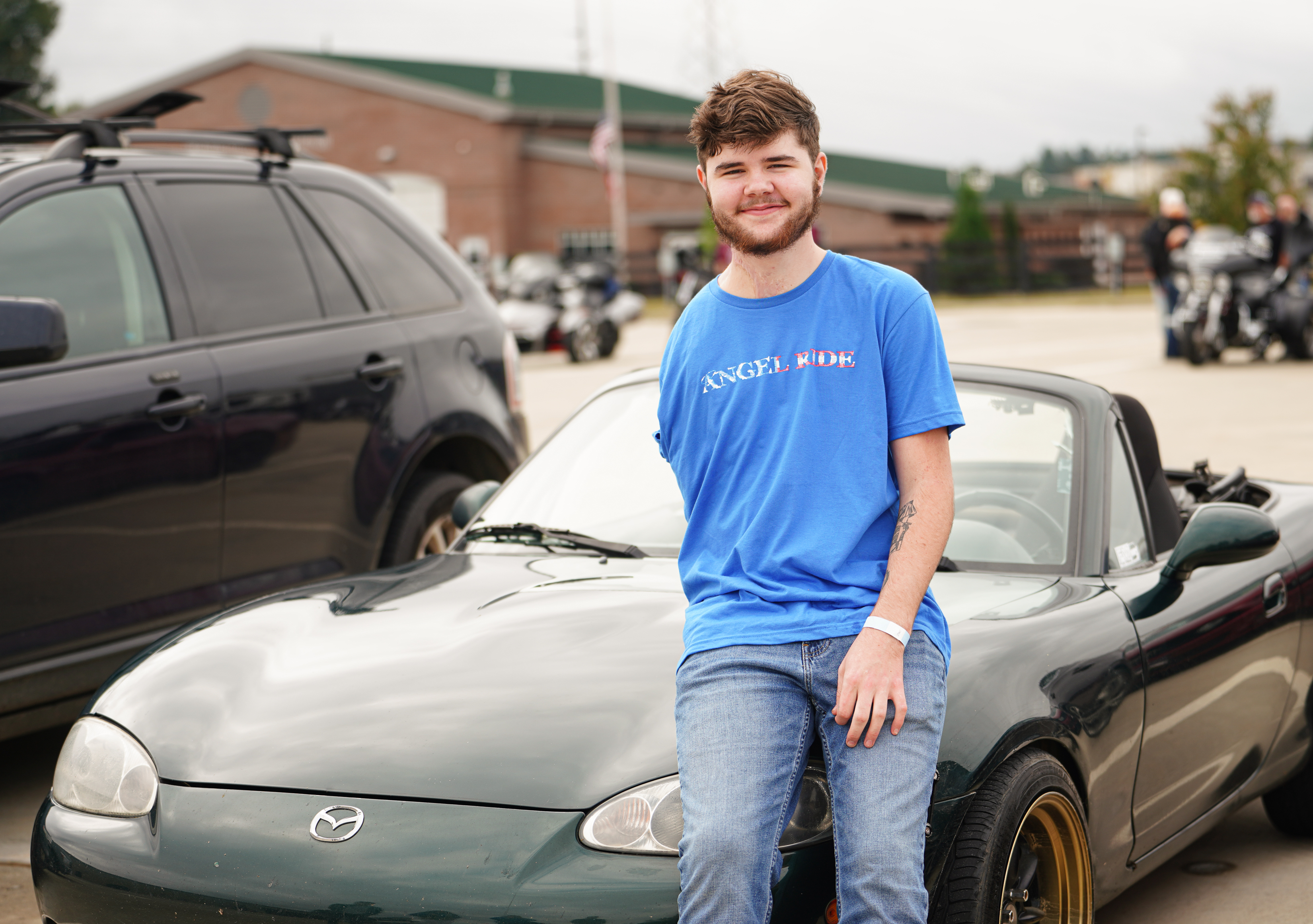 Jacob Dake sits on the front of his 2001 Mazda Miata before participating in the Angel Ride, a non-profit fundraiser that raised $42,077.65 for the Oglethorpe County High School grad who was injured in a severe vehicle accident last September. (Sidney Chansamone/The Oglethorpe Echo)