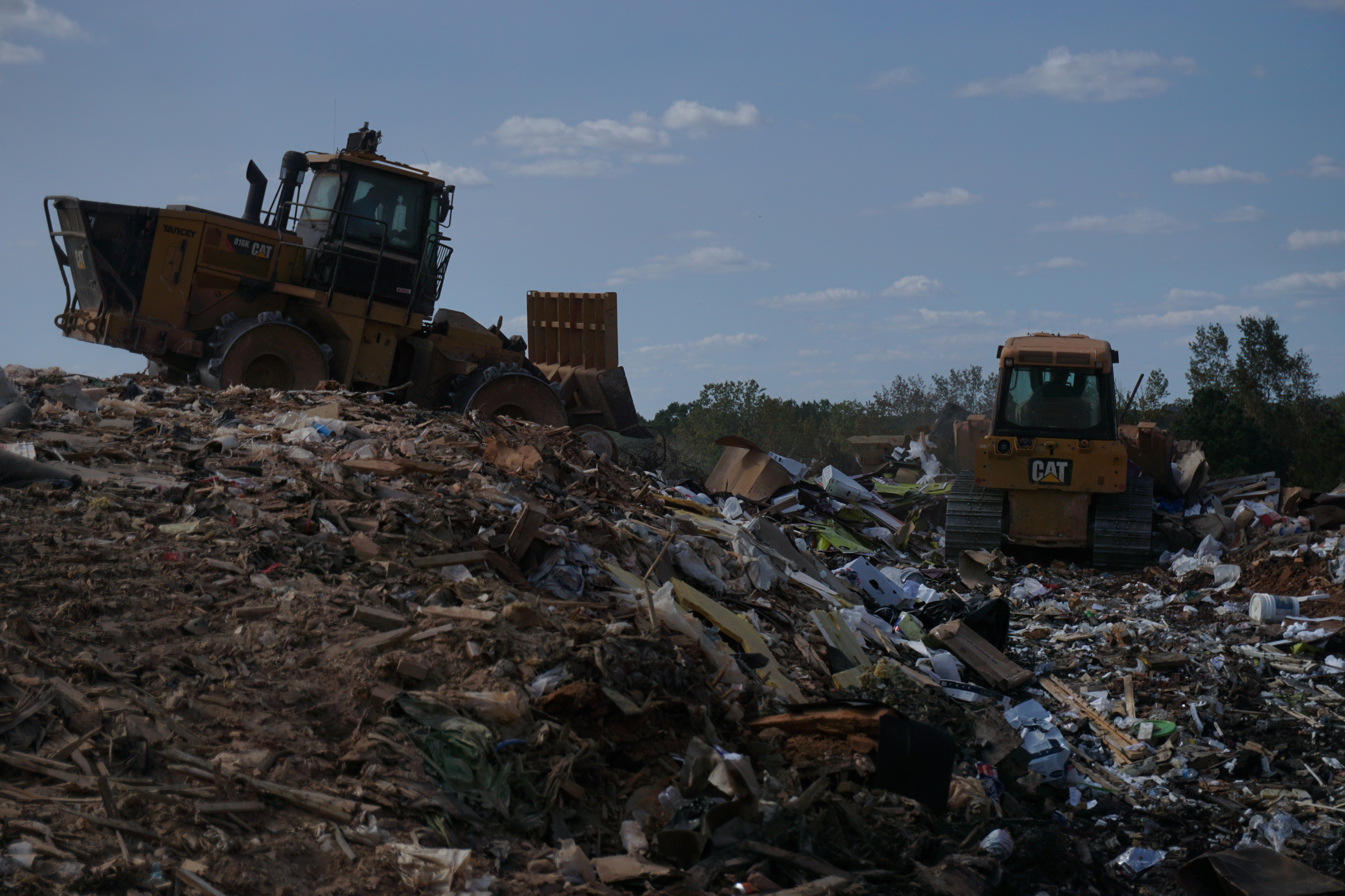 A trash compactor (left) and a bulldozer move trash at the Oglethorpe County Construction and Demolition Landfill. The Board of Commissioners on Monday changed the cost of larger loads and placed a restriction on who can use the landfill. (Photo/Jay Reece)