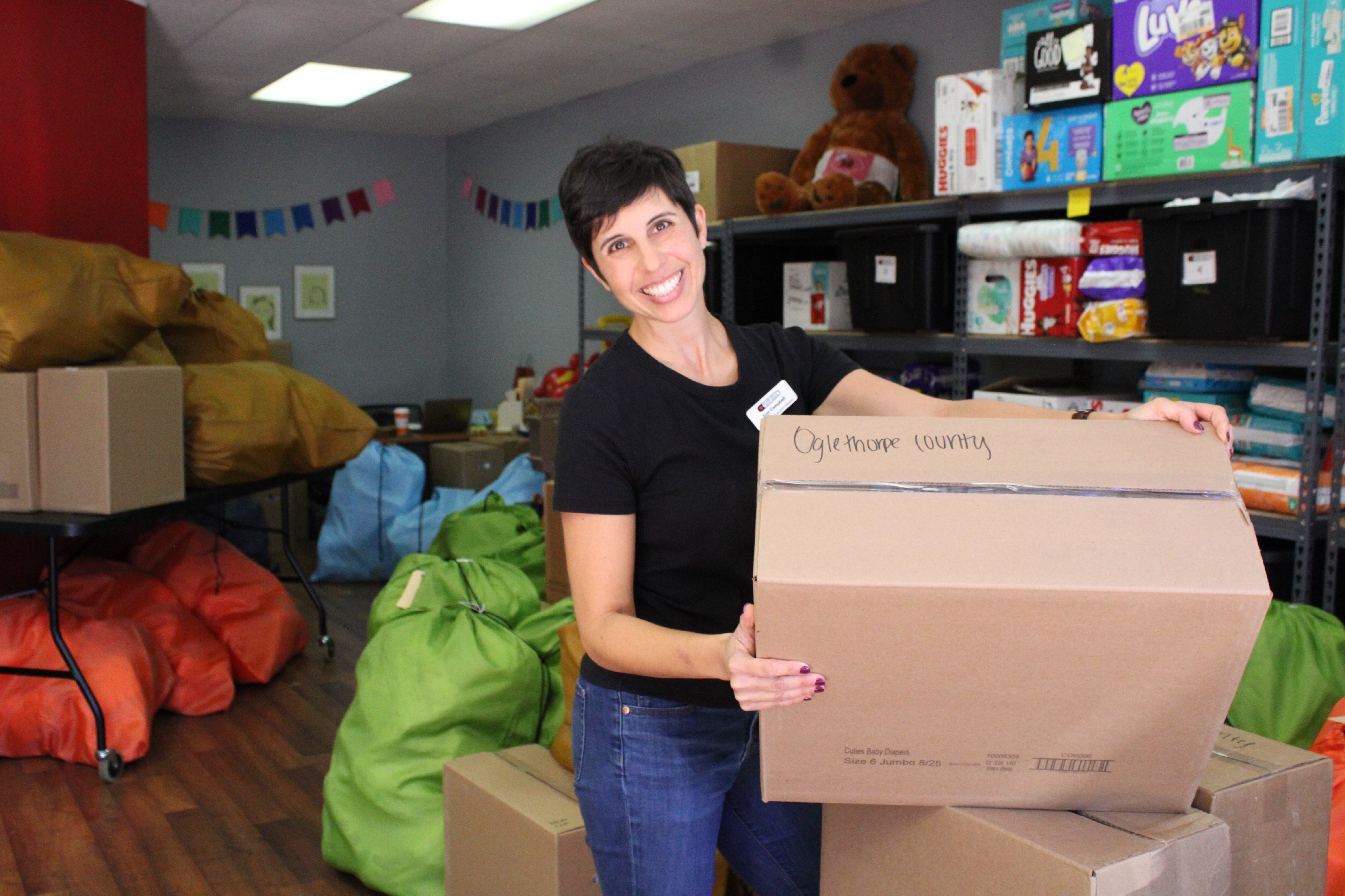 Erin Campbell, founder of the Athens Area Diaper Bank, moves boxes labeled for Oglethorpe County at the organization's warehouse in Bogart. The nonprofit sends free diapers to locations in Oglethorpe County. (Sarah Donehoo/The Oglethorpe Echo)