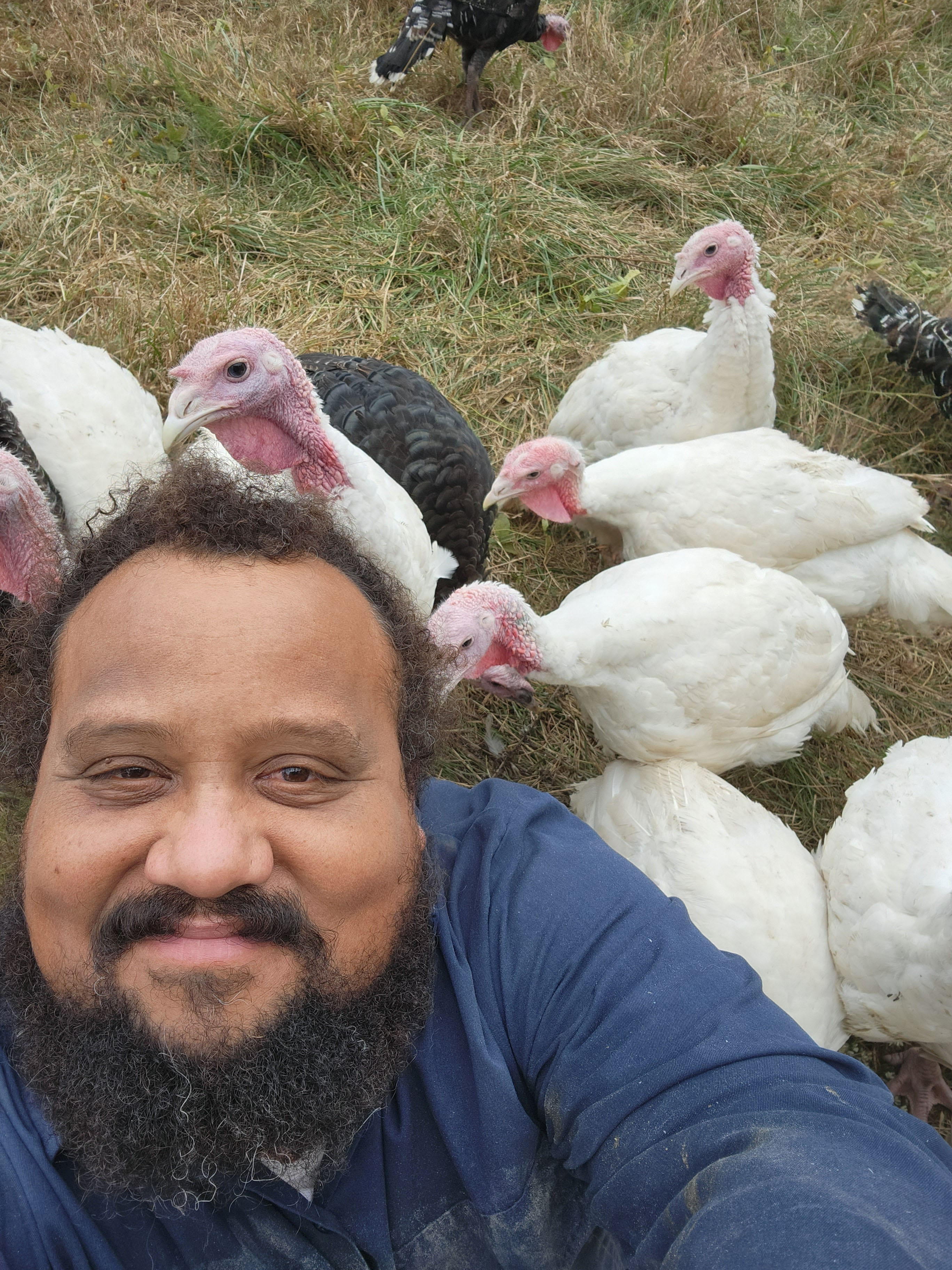 Gabriel Jimenez takes a photo of himself and some of the turkeys at Caribe United Farm in Crawford. Jimenez and Tamita Brown, his wife, have raised turkeys, specifically for Thanksgiving, there since 2019. Gabriel Jimenez/For The Oglethorpe Echo