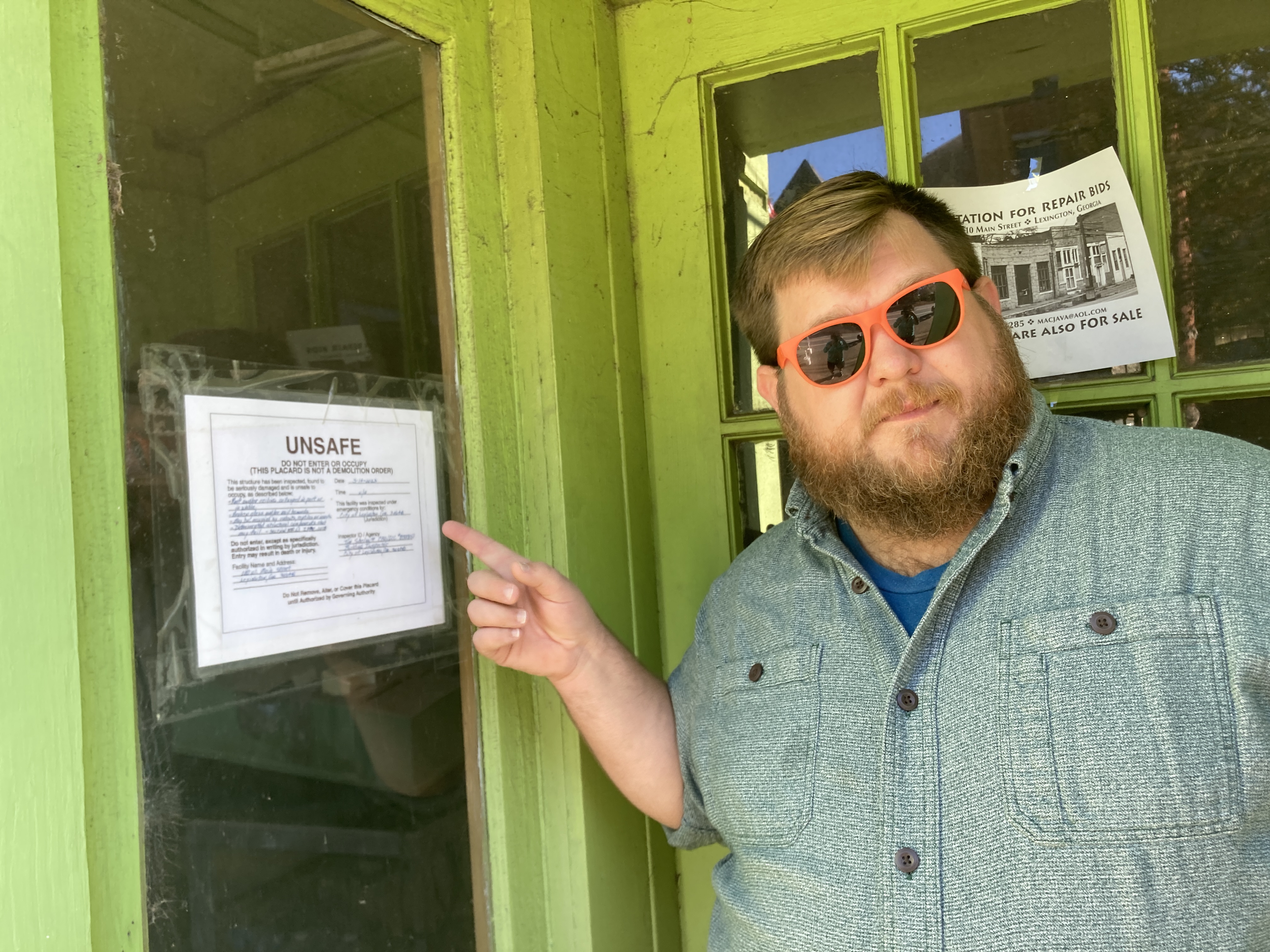Glynn Segars, owner of Community Cigar and member of the Lexington Downtown Development Authority, points out the notice on the window in a building along Main Street in downtown Lexington. “It’s a concern for public safety, it’s a concern for business development and it’s a concern for historic preservation,” he said.