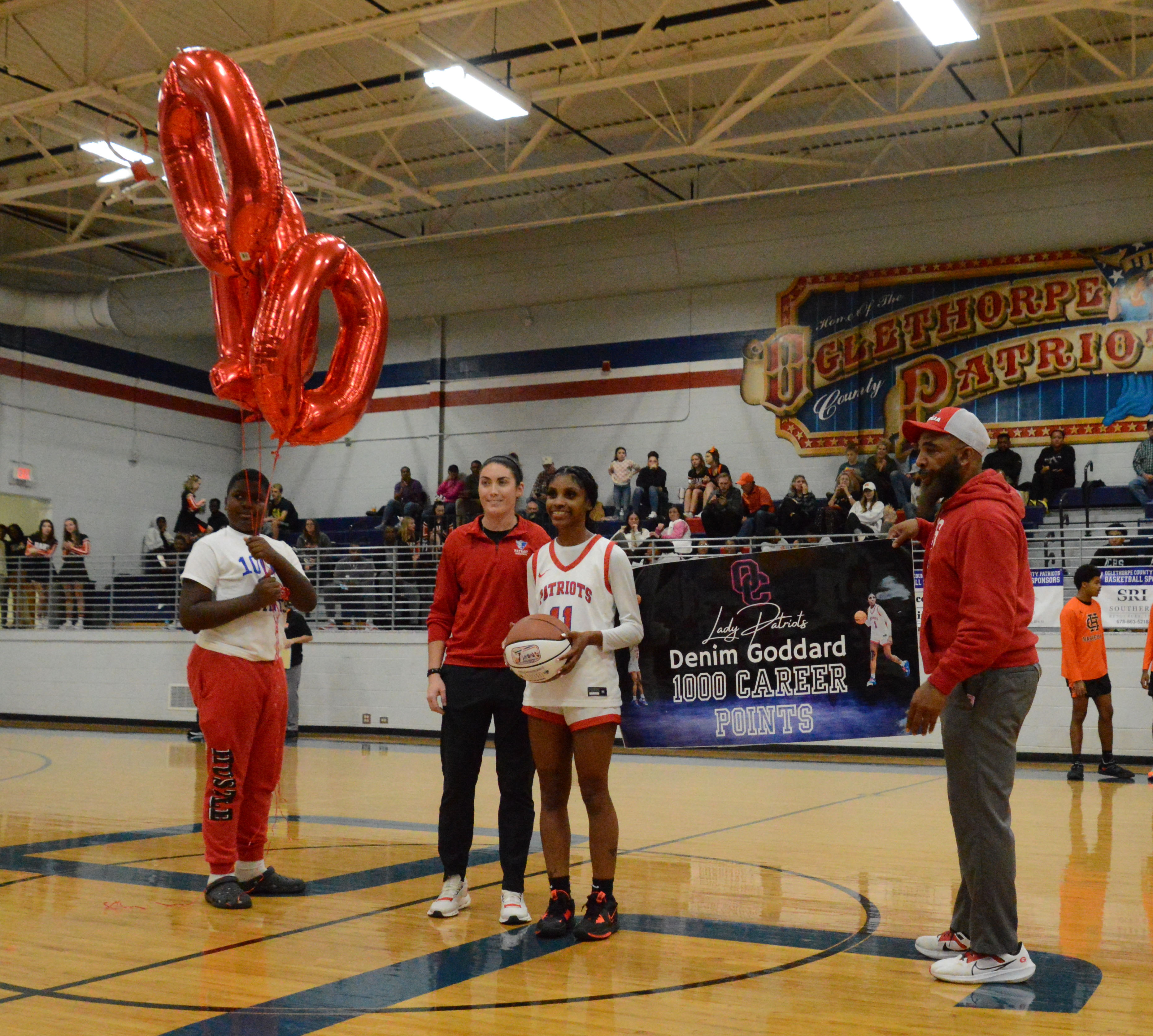 Senior Denim Goddard, standing with coach Brianna Dickens, is recognized for scoring 1,000 career points after Oglethorpe County defeated Hart County 60-54 on Monday. Goddard reached the milestone in a game at Hart County on Dec. 9. (McCain Bracewell/The Oglethorpe Echo)