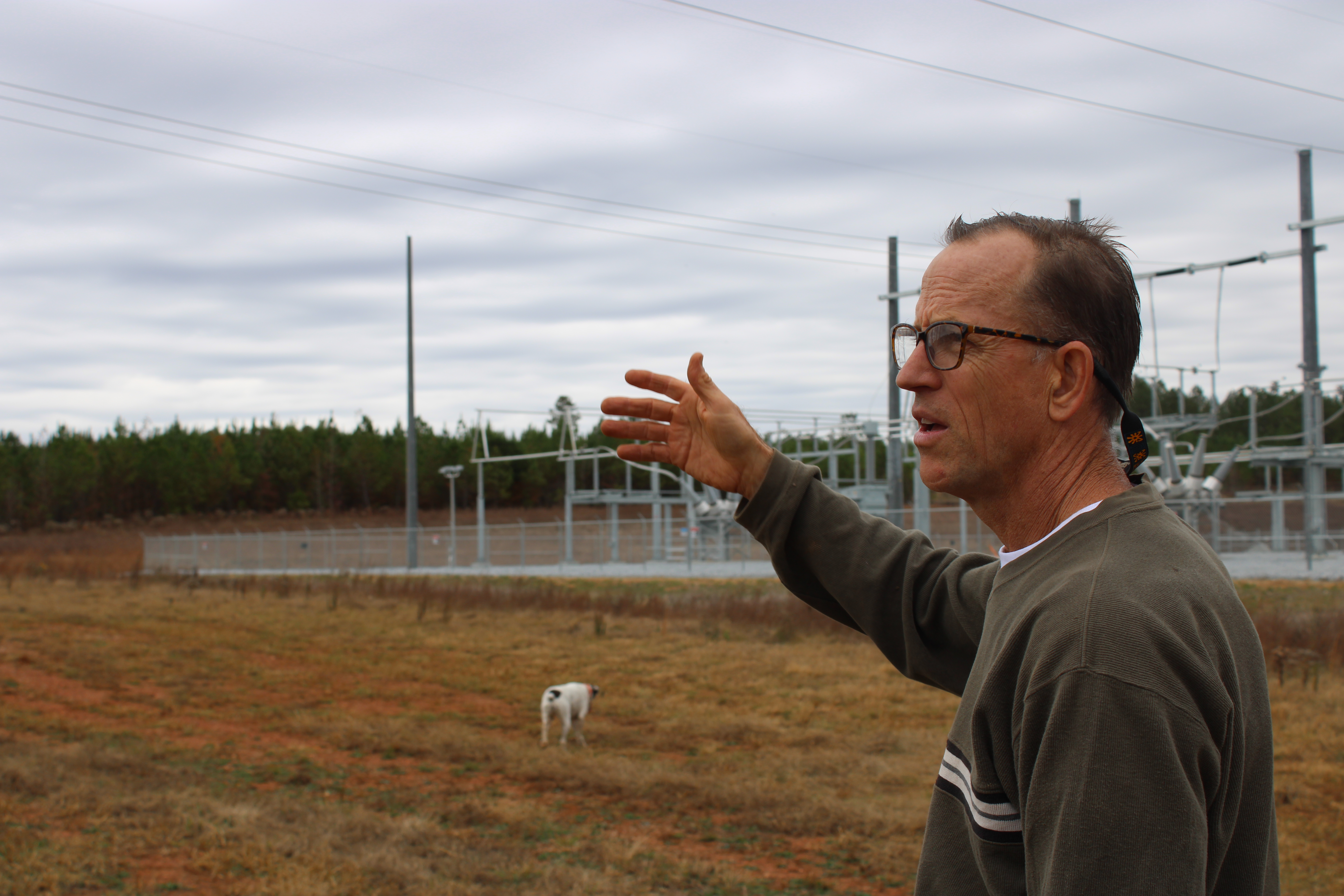 Oglethorpe County resident John Burt, along with his dog, Dixie, shows the substation that converts the power from the Timberland Solar Farm Project on Goose Pond Road, which is feet from his property line. Burt (top) shows where runoff from the solar farm has impacted his property.