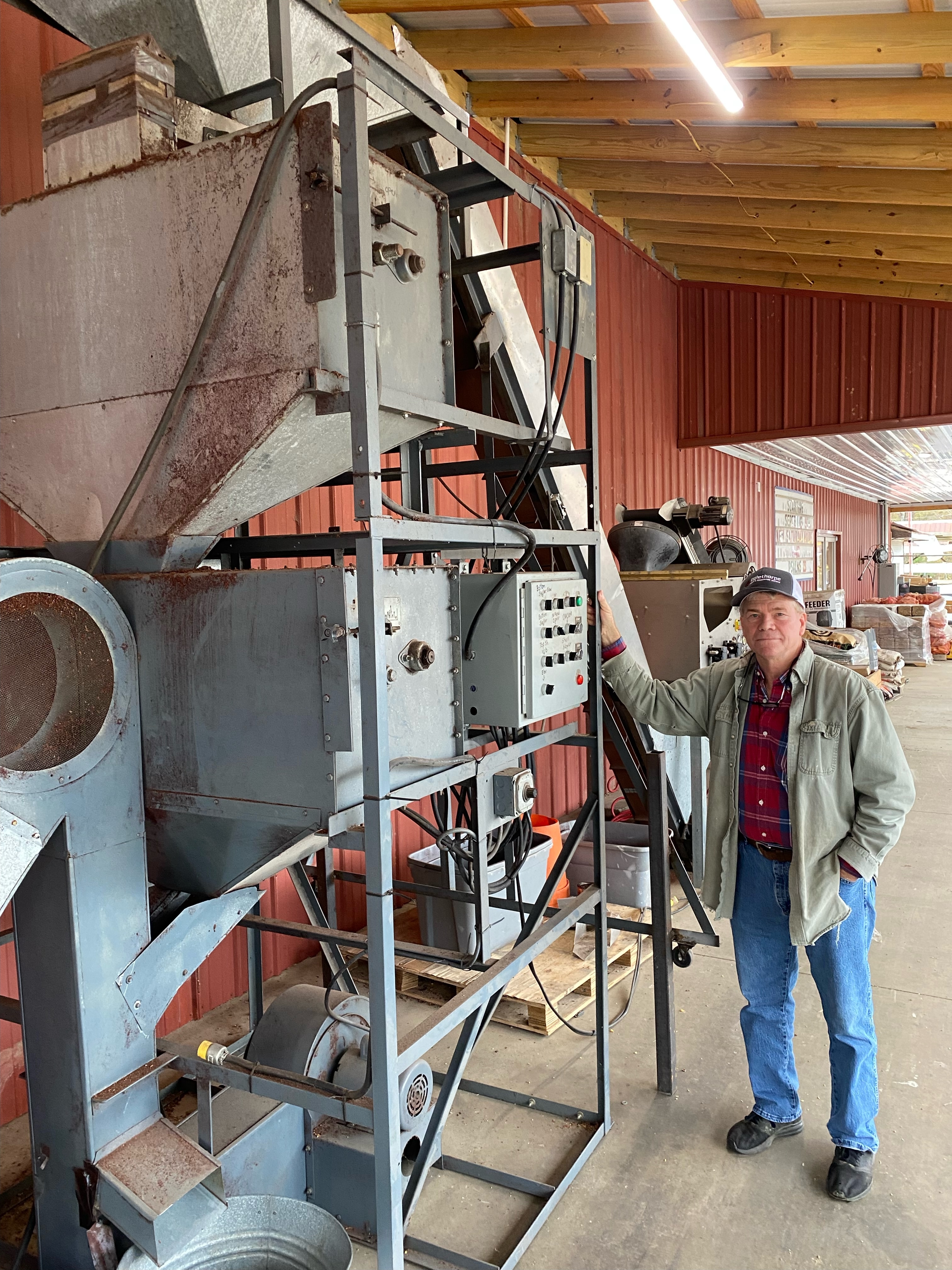 Danny Sanders, owner of Oglethorpe Feed and Hardware Supply, stands next to the store's pecan cracker-sheller. It can process 10 pounds of pecans a minute. (Dink Nesmith/The Oglethorpe Echo)