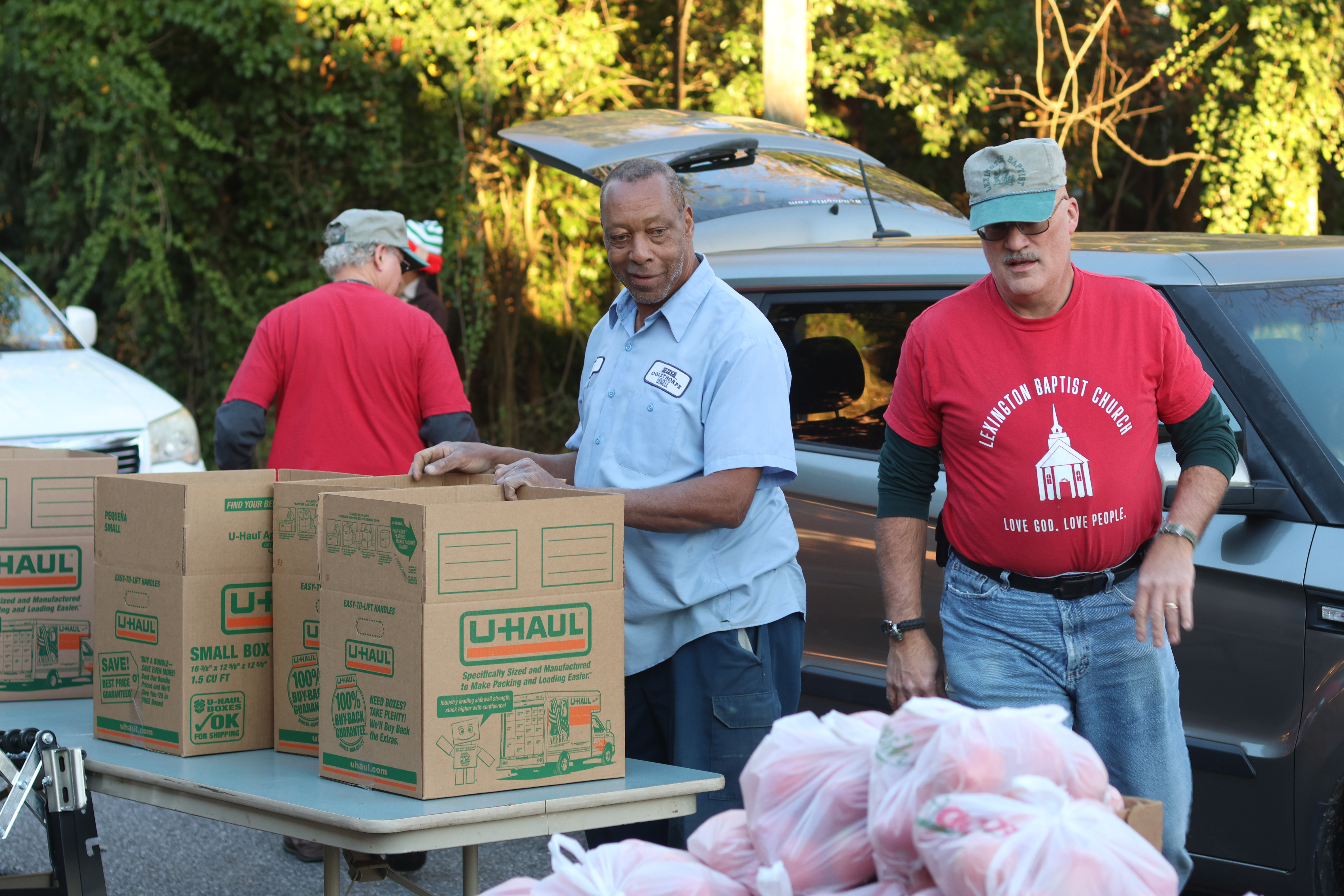 Will Eberhart (left) and Douglas Cosby move and organize boxes of food before they load cars at the Lexington Baptist Church’s monthly food pantry in December. Cars wind around the block in downtown Lexington waiting to receive the food. (Samantha Hurley/The Oglethorpe Echo)