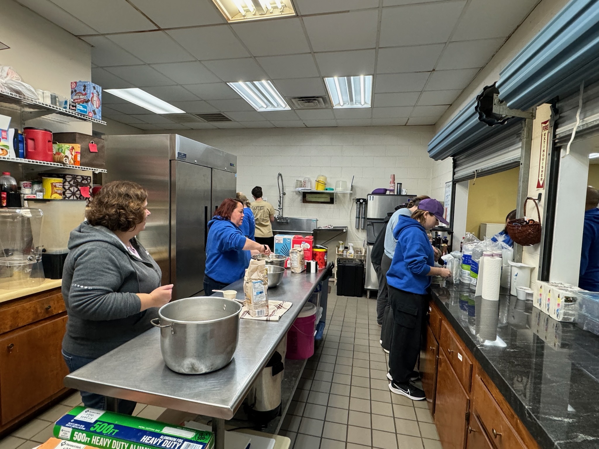 Susan Flores (from left), Jeanne Jones, Monica Patrick and Faith Dynarski-Hughes prepare the food for the Oglethorpe County High School marching band's pancake breakfast fundraiser last month. The band’s booster club holds fundraisers throughout the year to help with the costs of instruments, uniforms and other items. (Submitted Photo)
