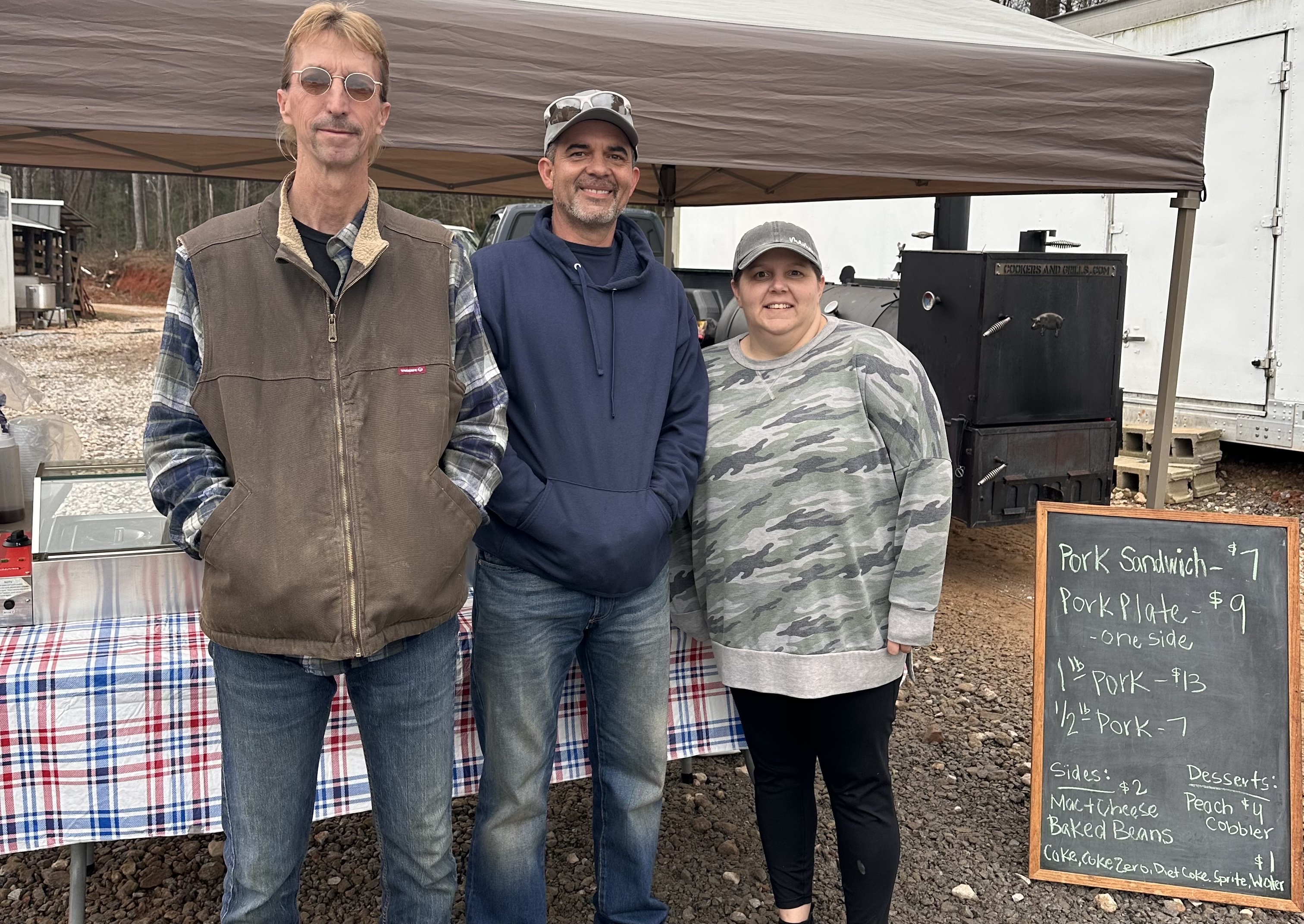 Todd Smith (from left), Mark Atkins and Katie Armour welcome folks to Nature Harvest Meat Company’s grand opening celebration for its custom processing/in-store meat counter season on Feb. 10. Atkins, the owner of Second Chance BBQ, collaborated with Nature’s Harvest to cook meat for customers at the event. (Gianna Sandy/The Oglethorpe Echo)