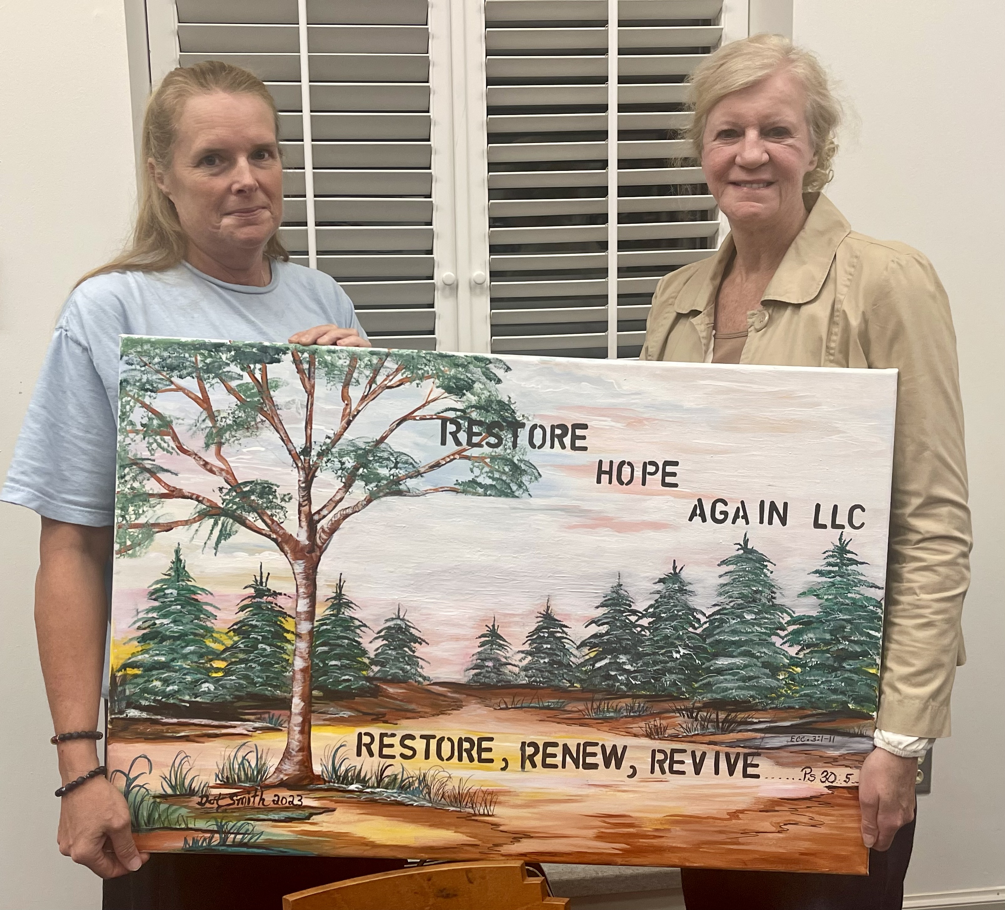 Miriam Pledger (left), founder of Restore Hope Again, holds a painting of the support group’s logo with Patricia Shelton (right), a member of the administration team. Restore Hope Again is a Christian-based support group in Oglethorpe County.