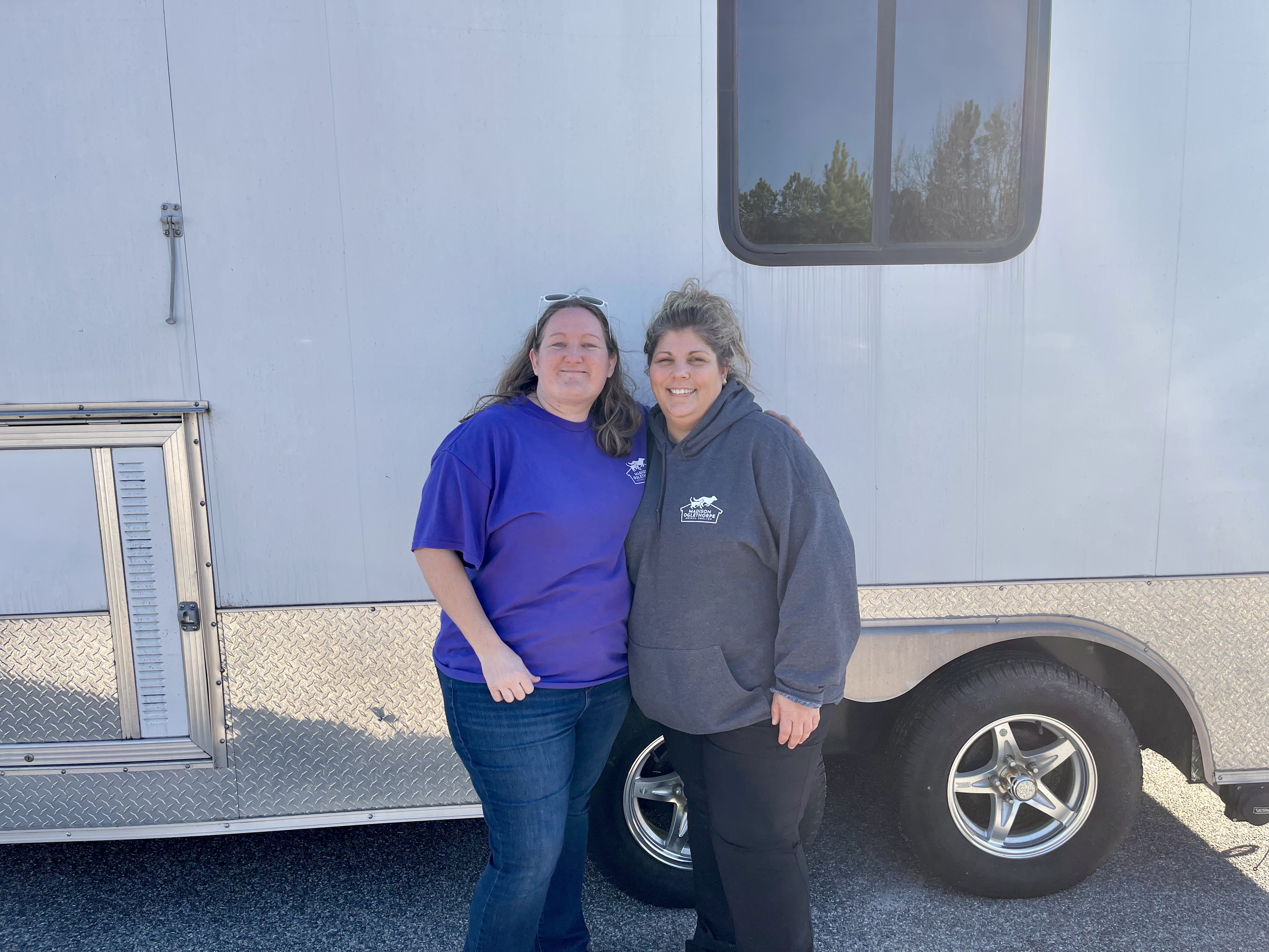 Madison Oglethorpe Animal Shelter Grants Coordinator Shaina Knight (left) and Shelter Director Erica Hendrix (right) standing in front of the trailer the shelter will operate the free vaccine clinic out of. The clinic is part of the MOAS Underserved Animal Project and is sponsored by the Banfield Foundation and MOAS Pets. (Lee Short/The Oglethorpe Echo) 