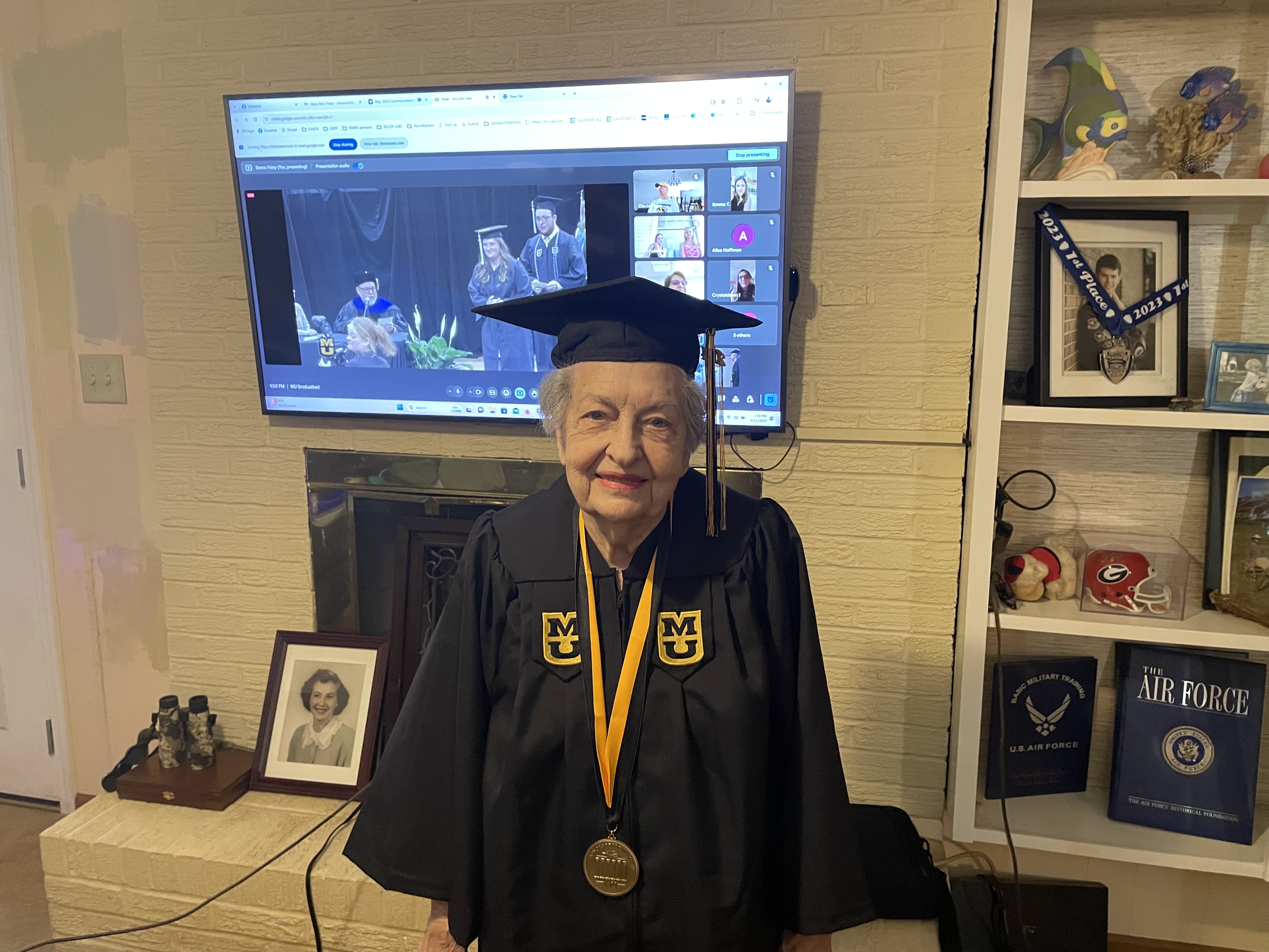 Mary Foley poses in front of the television live-streaming her graduation ceremony on May 11. Foley is the fifth member of her nuclear family to graduate from the University of Missouri. (Jack Keys/The Oglethorpe Echo)