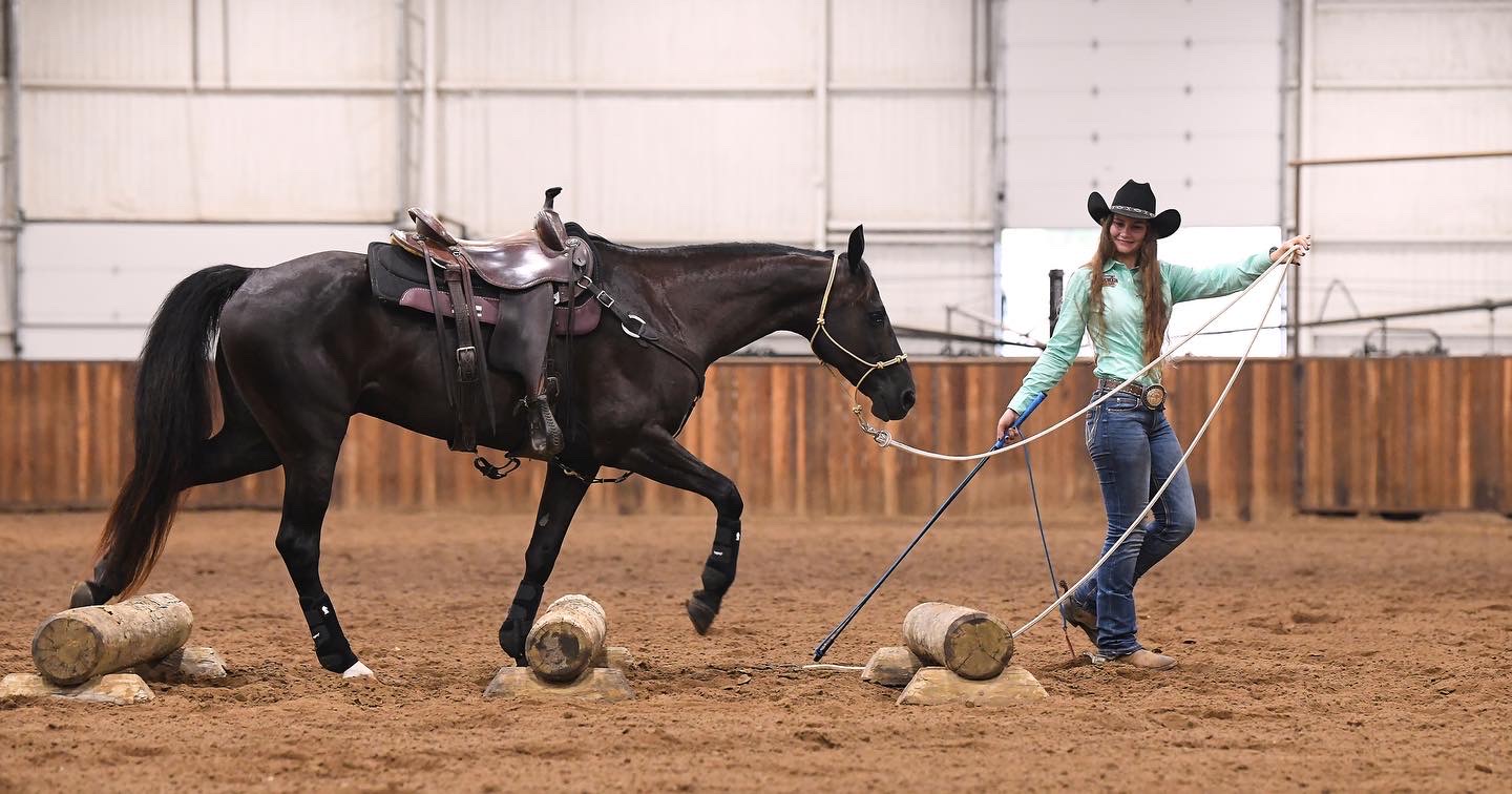 Raven Cooper demonstrates how to get a horse to walk calmly over obstacles at her Clinton Anderson horse training certification, with horse AJ in Arkansas in July 2022. Cooper gives back what she has learned to the 4-H community by coaching students in horse quiz bowl and judging knowledge. (Submitted Photo)