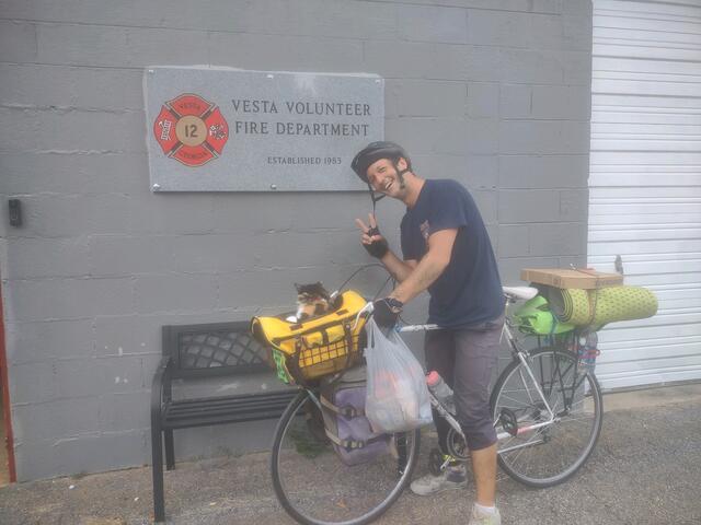 Filmmaker Caleb Werntz and Marilyn Monroad, his calico cat, stopped to spend the night at the Vesta Volunteer Fire Department last week. Werntz is on a cross-country cycling trip that will end on the Florida Gulf Coast. (Submitted Photo)