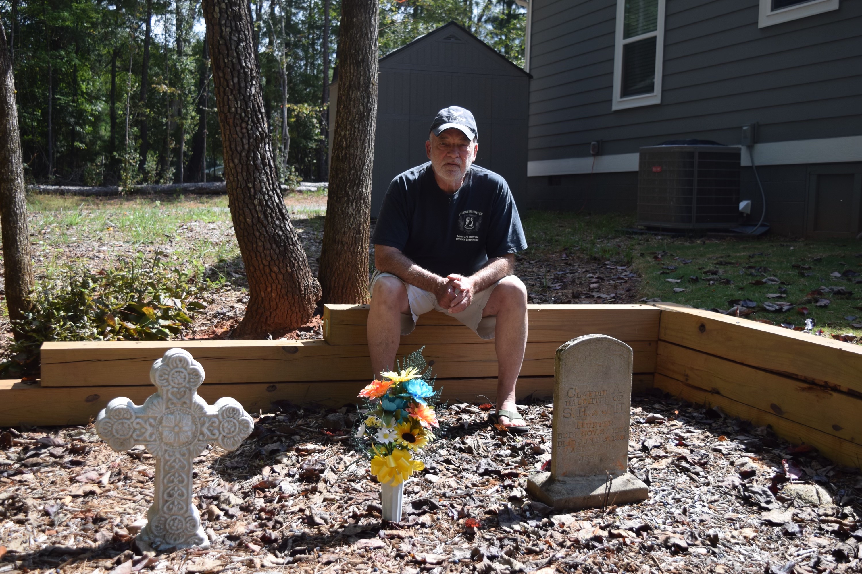 Don Davis, a retired veteran, sits along the wall he built to help protect the graves he maintains on his property on Buddy Faust Road in Lexington. Not much is known about the people buried in the three graves next to his house. (MARY CATHERINE DODYS/THE OGLETHORPE ECHO)