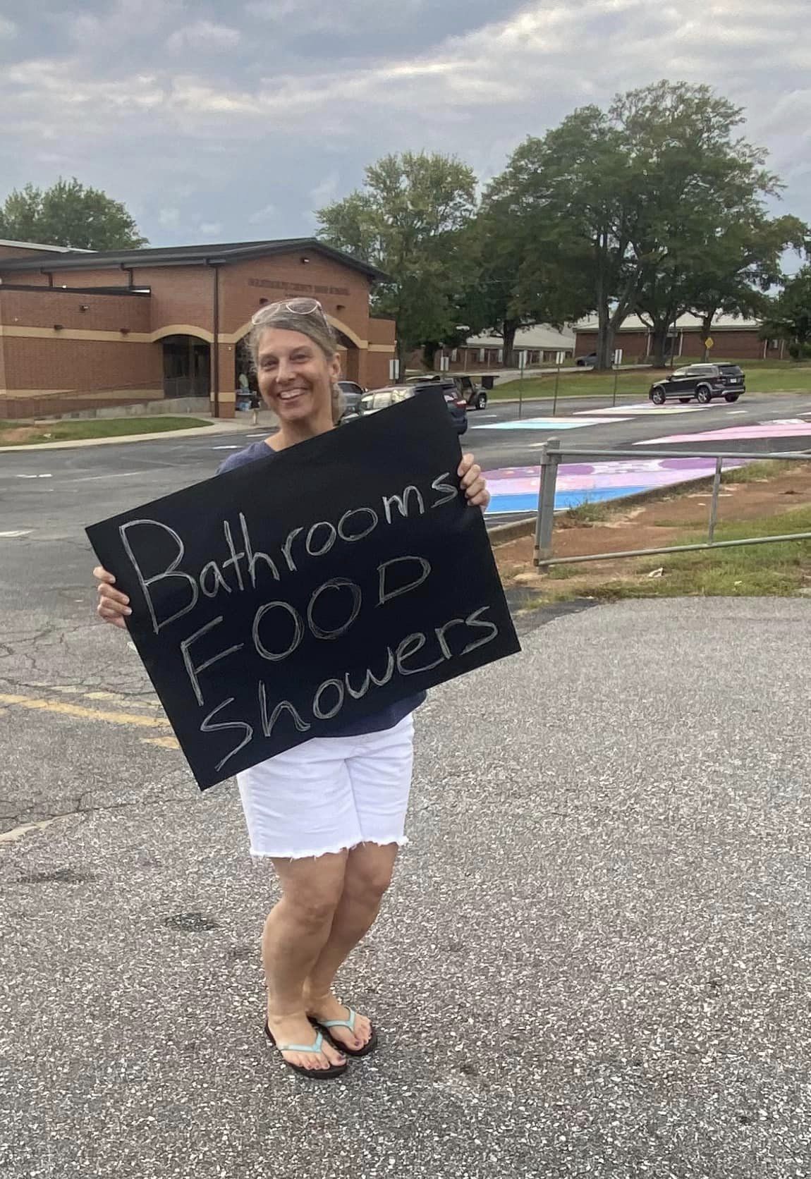 Roseanna Ames with Oglethorpe County Schools holds a sign and stands along Highway 78, in front of the OCHS gym. Those who stopped received spaghetti meals, bottled water and other necessities. Some took food to people affected by the damage and power outages. (Submitted Photo)