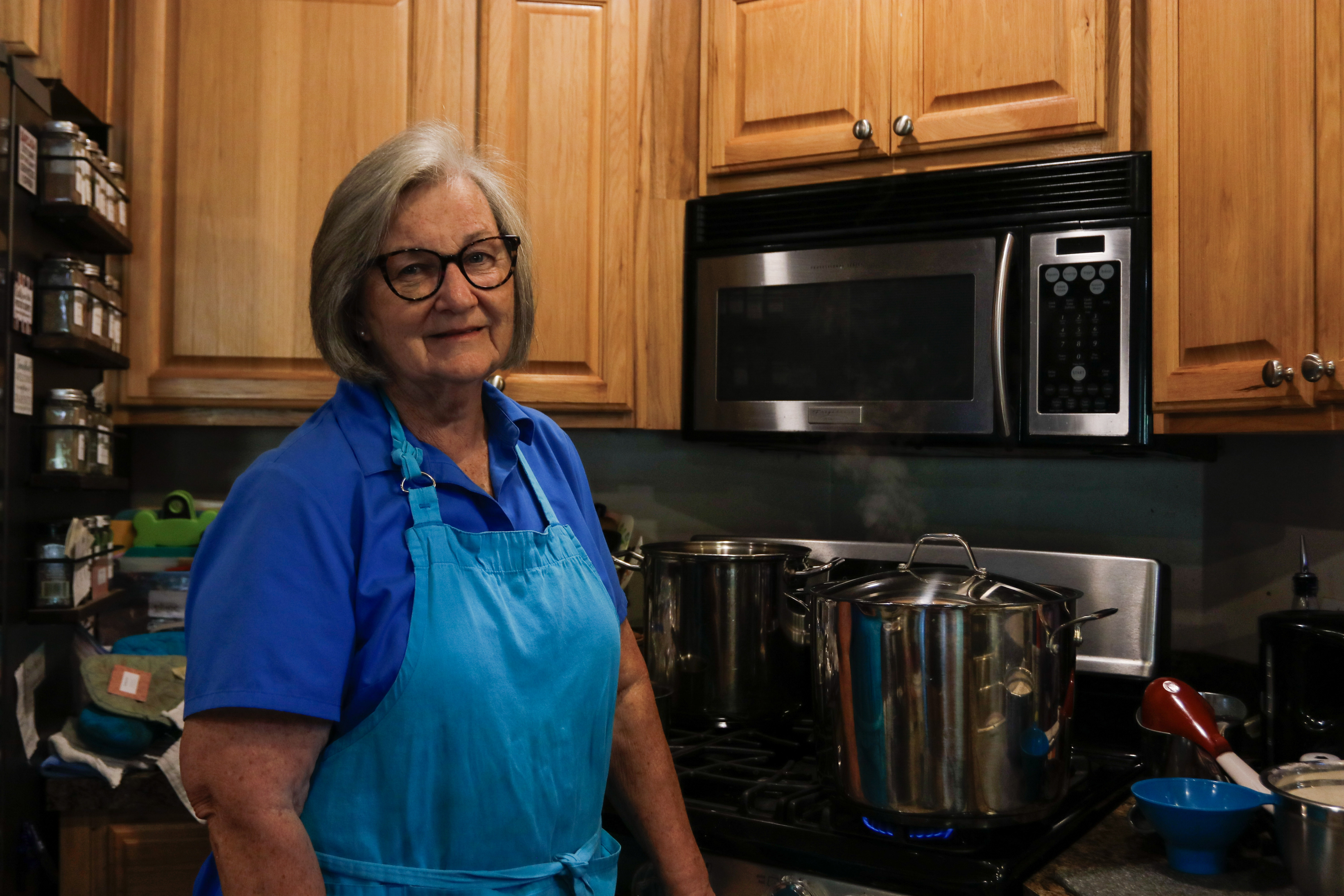Kathy Howell smiles in front of her stovetop where she makes her jams and jellies. All of her Moonflower Farm products are made out of her Lexington home. (Kendall Kelly/Oglethorpe Echo)