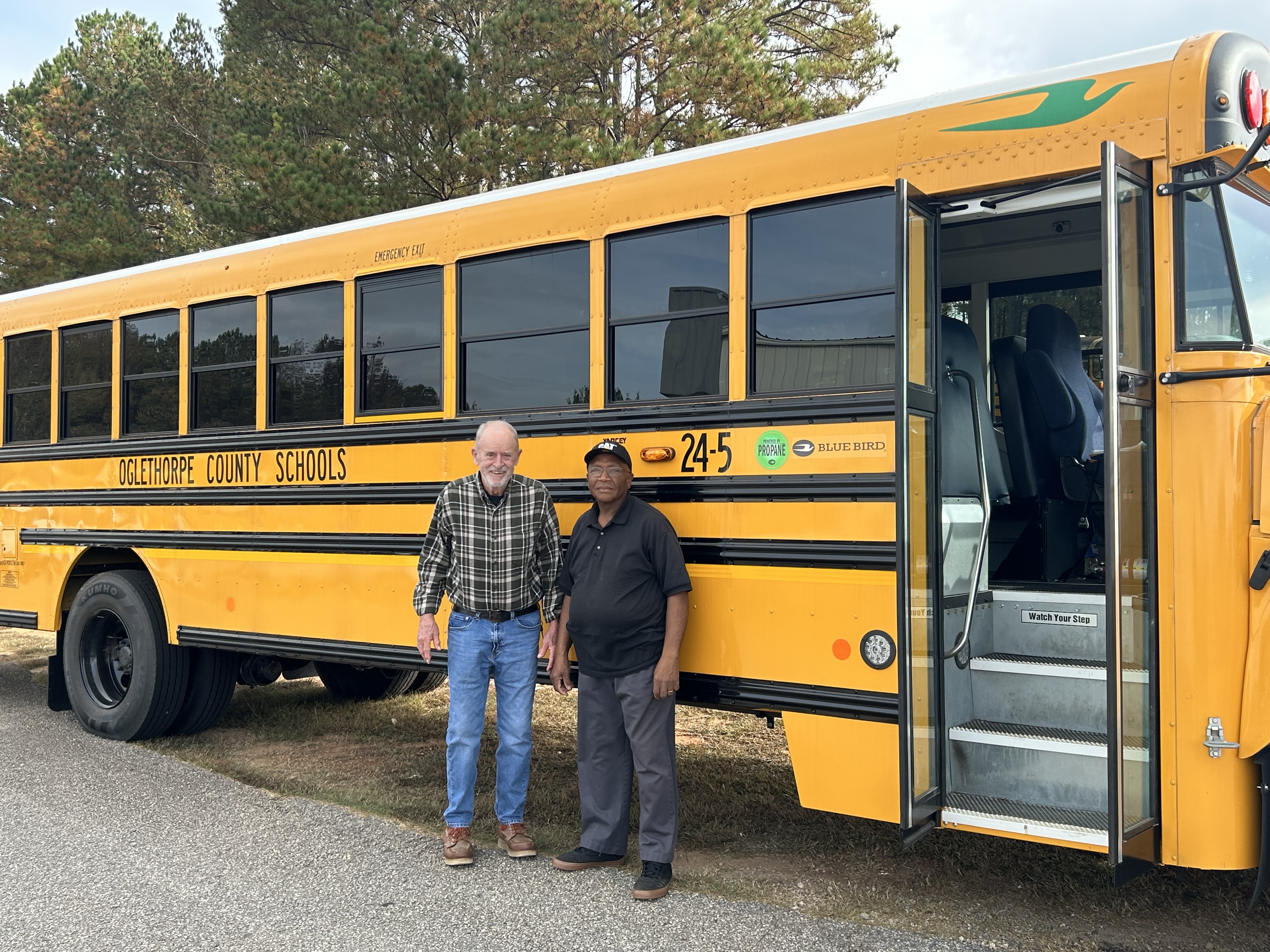 Oglethorpe County School System bus drivers Jerry Jones and Roy Walter stand in front one of the new propane buses on Monday. Three propane buses have been added to the system’s fleet to increase clean energy and safety initiatives, officials said. (Submitted Photo)