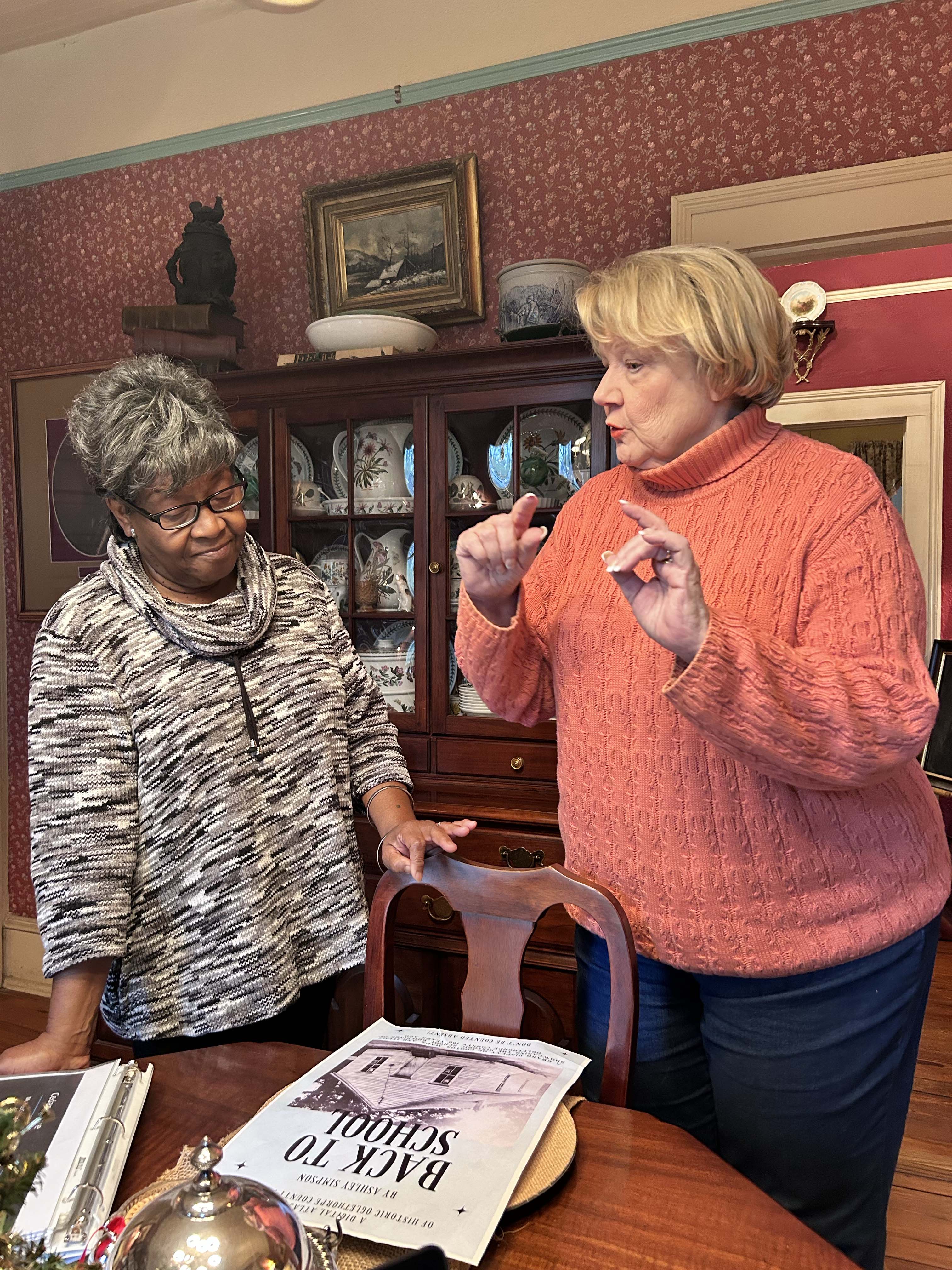 Maggie Mobley (left) and Ashley Simpson stand in Simpson’s house in Athens as they discuss her work with the Atlas Project and Mobley's experiences attending a one-room school house. Simpson has researched churches and schools in Oglethorpe County since the Digital Atlas Project started in 2020. (McCain Bracewell/The Oglethorpe Echo)