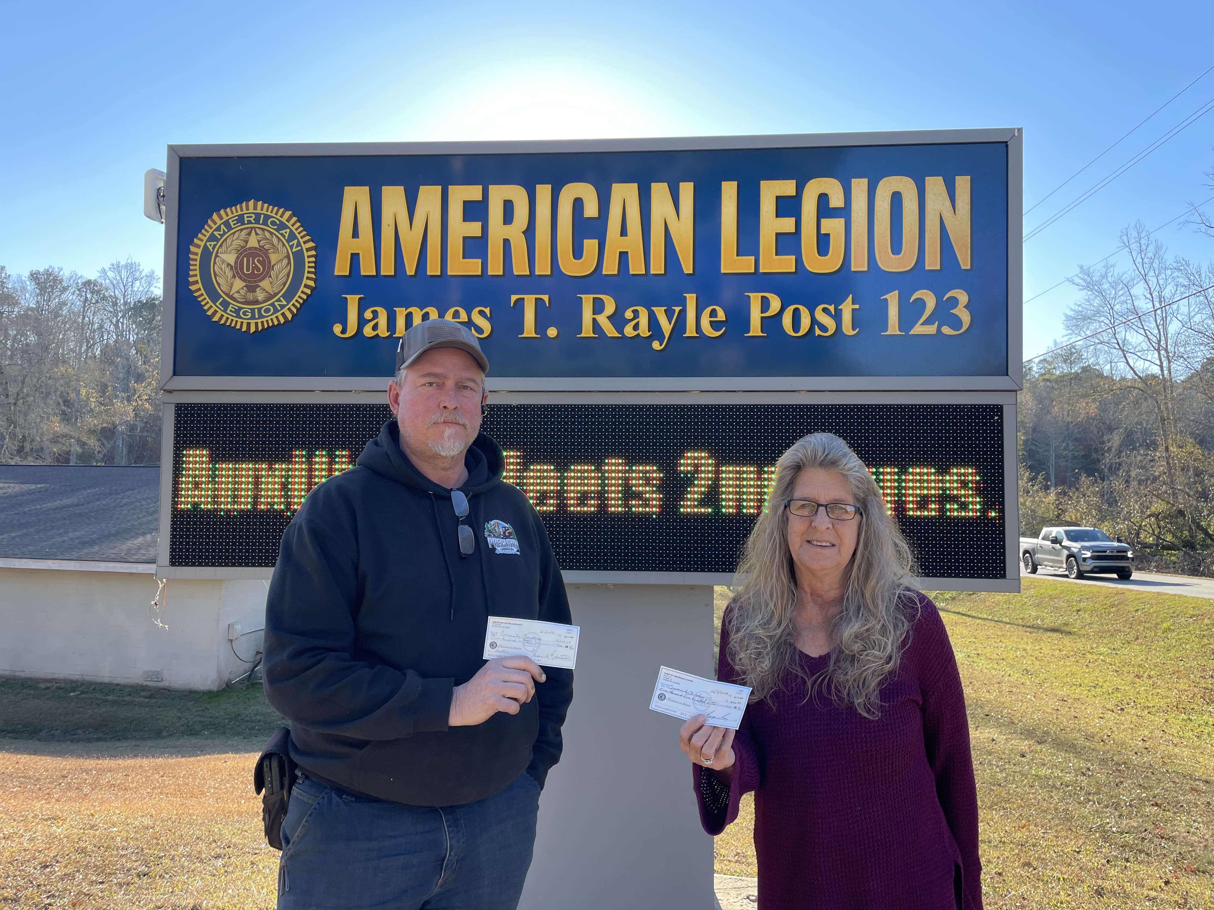 Commander of the Sons of the American Legion Billy Bob Shellnut (left) and President of the Auxilary Donna Churchill (right) present checks to the Community Christmas of Oglethorpe County. The local American Legion members have been "longtime" supporters of the non-profit. (Submitted photo)