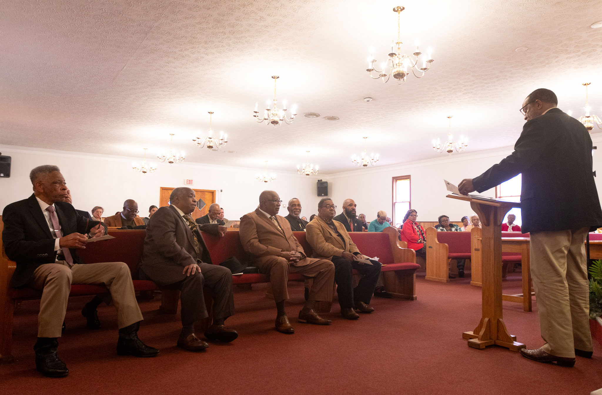 From left: Deacon Edgar Alexander, Bishop Calvin Turner, Reverend Clarence Burgess, and Deacon L. M. Echols sit in the front row of Mt. Zion Baptist Church in Stephens, Georgia as Reverend Dr. R. A. Hunter gives acknowledgements at the annual Dr. Martin Luther King, Jr. Program sponsored by the Concerned Men of Oglethorpe County on Jan. 20, 2025. Reverend Dr. R. A. Hunter is the president of the Concerned Men of Oglethorpe County. (Photo / Lux Corrona)