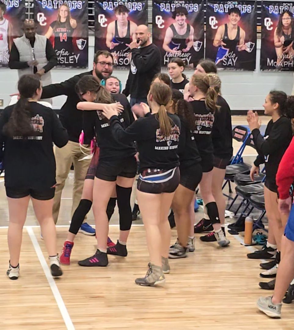 Brooklyn Myers (with headgear) is congratulated by Tessa Cosby and other OCHS teammates after a victory to help the girls wrestling team advance to its first state dual championship. The Patriots are one of eight teams remaining in Division 2. (Submitted Photo)