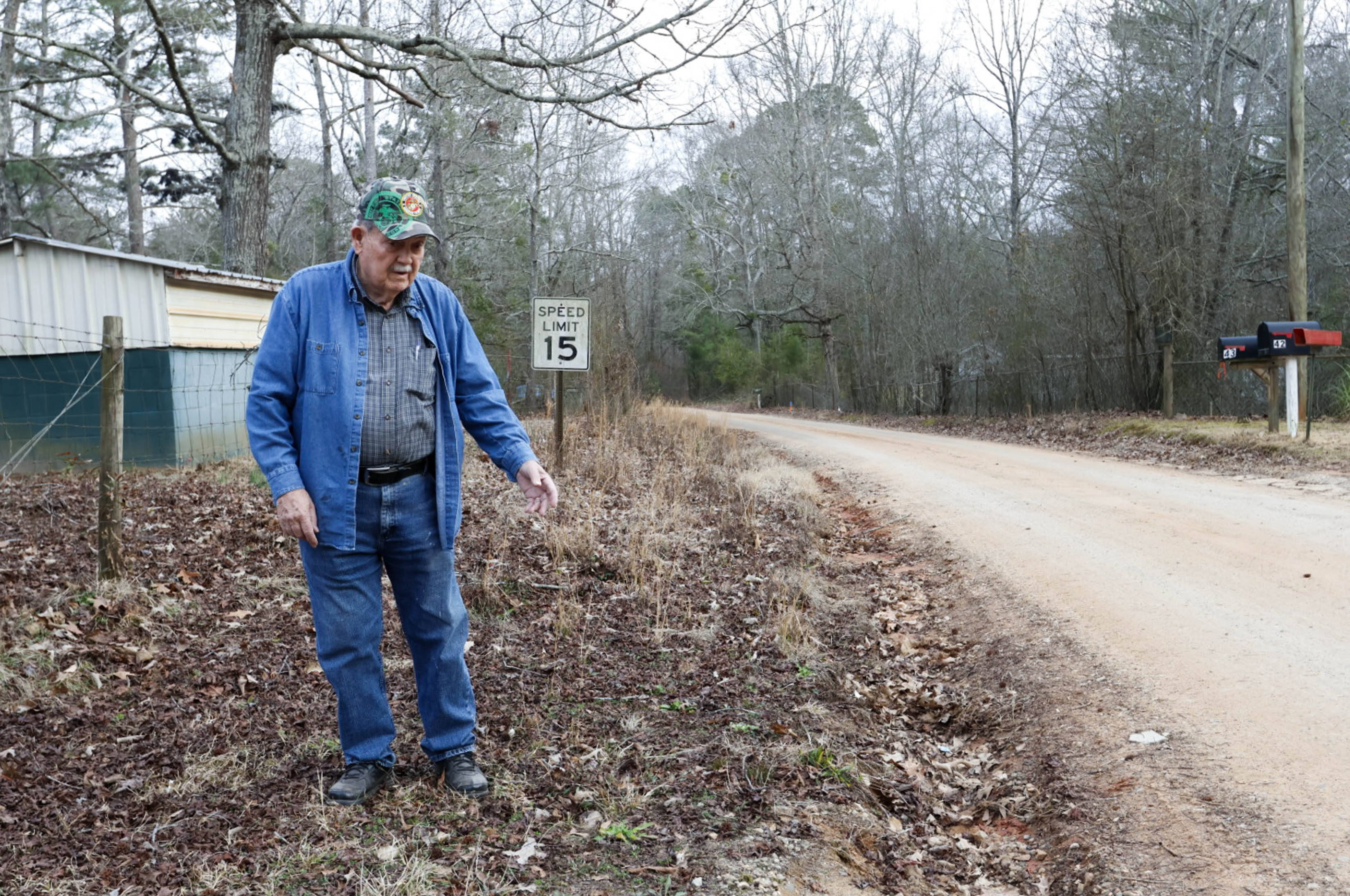 Randy Gordon, a resident of Oglethorpe County’s Almond Drive, stands where the edge of Almond Drive once was on Wednesday, Feb. 5, 2025. “When they come in and scrape [the road], they keep getting further and further to the center, and the cul de sacs where the ditches used to be are covered up,” Gordon said. (Photo/Felix Scheyer)