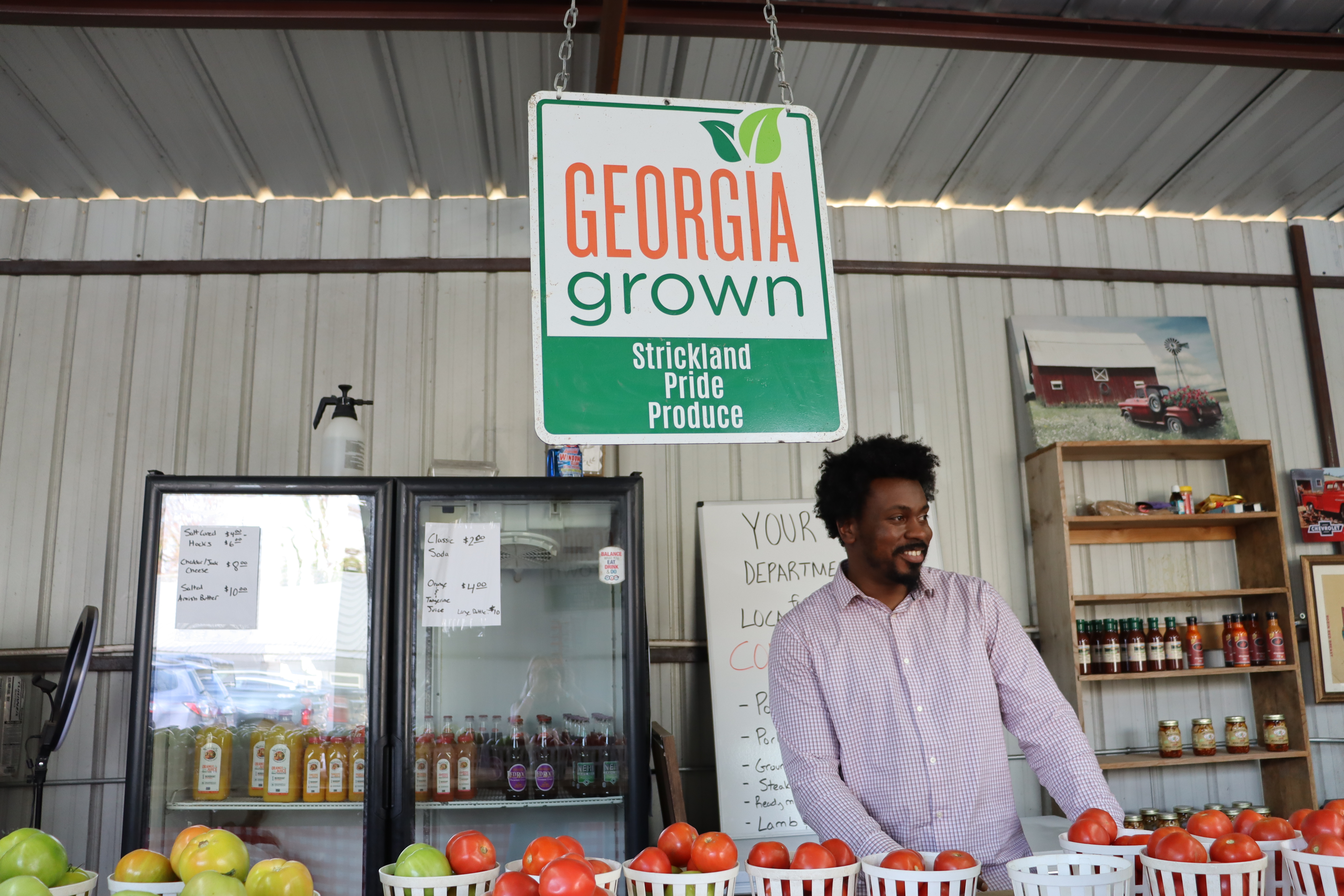 Owner and founder of Strickland Pride Produce, Kendall Strickland, stands behind the counter of his storefront location at 1129 Athens Rd, Crawford, GA. Strickland originally began his business from a successful roadside stand on E Main St. in Lexington, GA. This past Friday, the community joined him in celebrating one year in his storefront location. (Photo / Lilly Stone)