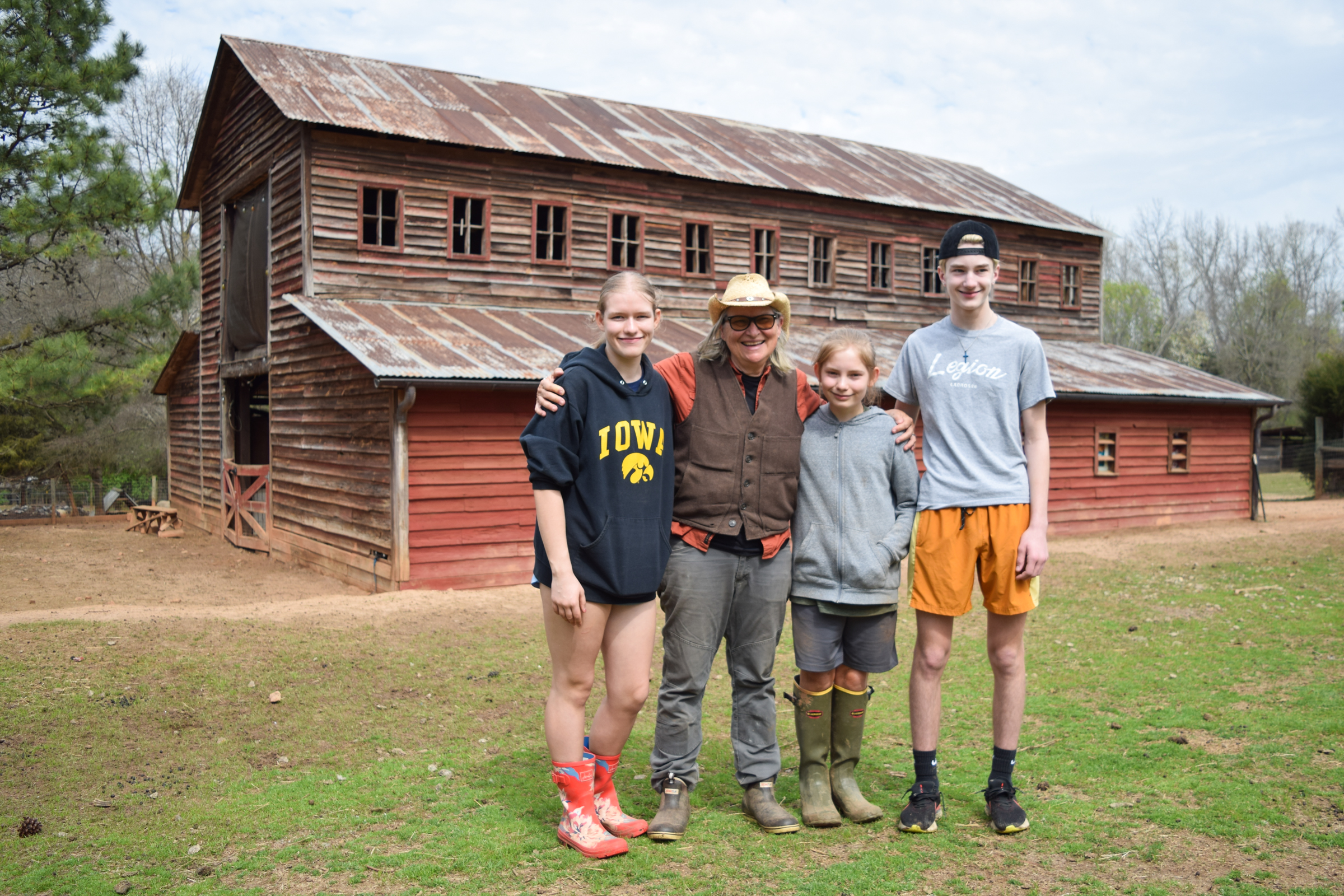 Kat Howkins, the owner of Sweet Olive Farm, a 501(c)(3) nonprofit organization that serves as a sanctuary for a wide variety of animals in Winterville, poses with Lydia and Ezra Haag and Memphis Friel (left to right).