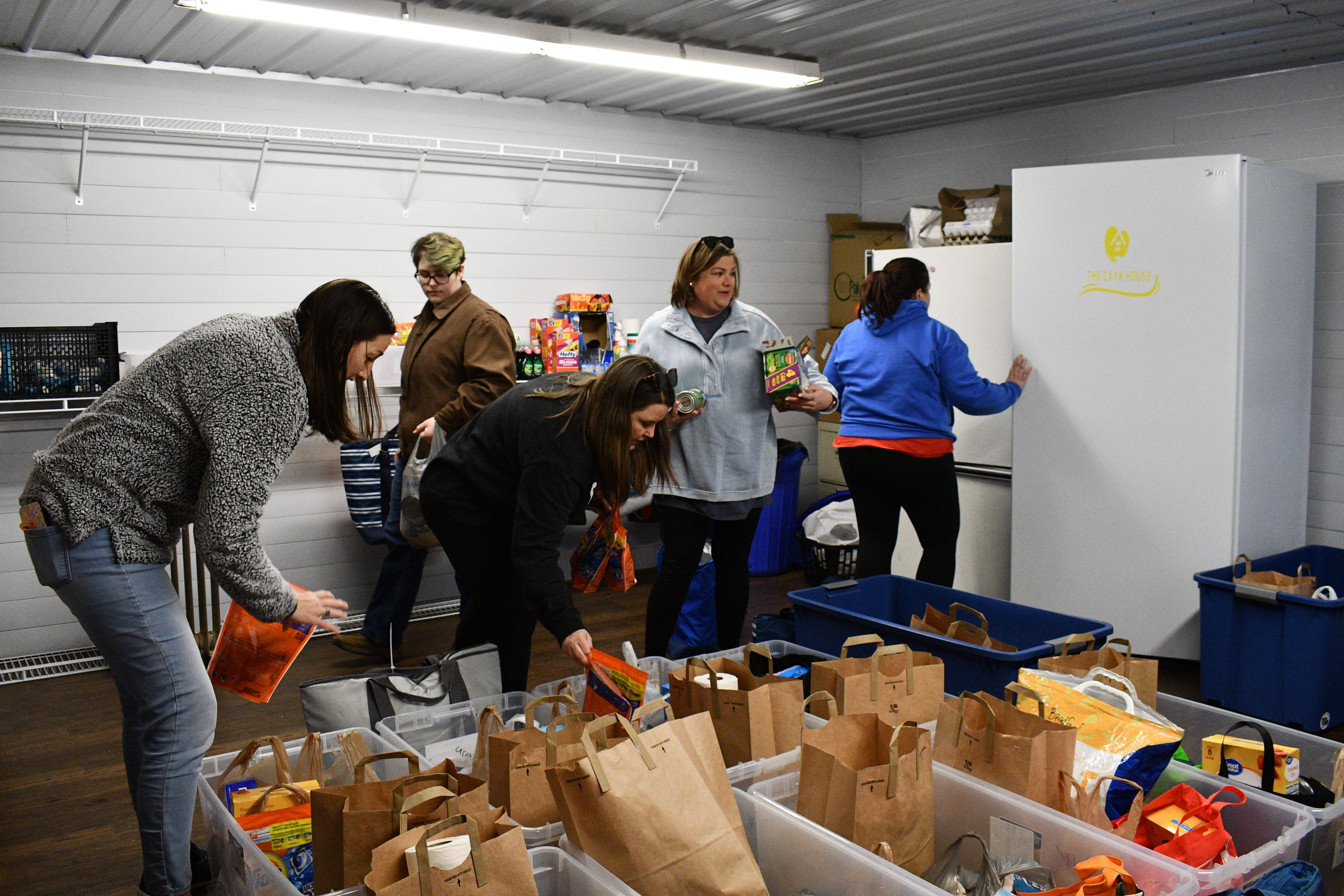 Volunteers with the CAYA House pack donation bins and refrigerator bags ahead of the nonprofit's February delivery. The organization delivers to an average of 10 families a month around Oglethorpe County. (Photo/Jennifer Xia)