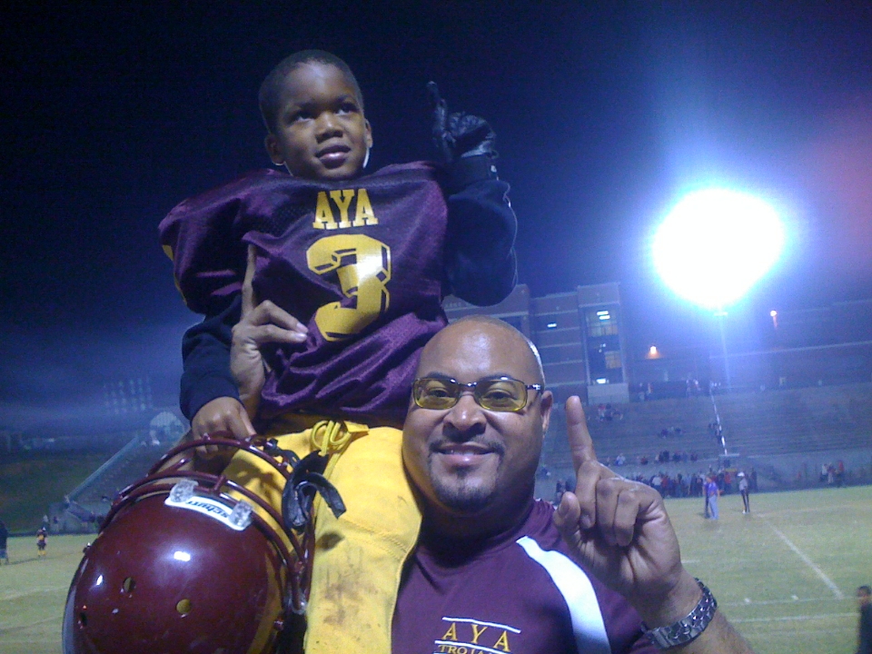 Jordan Johnson sits on his dad, James Johnson's, shoulder after a little-leauge football game. (Submitted photo)