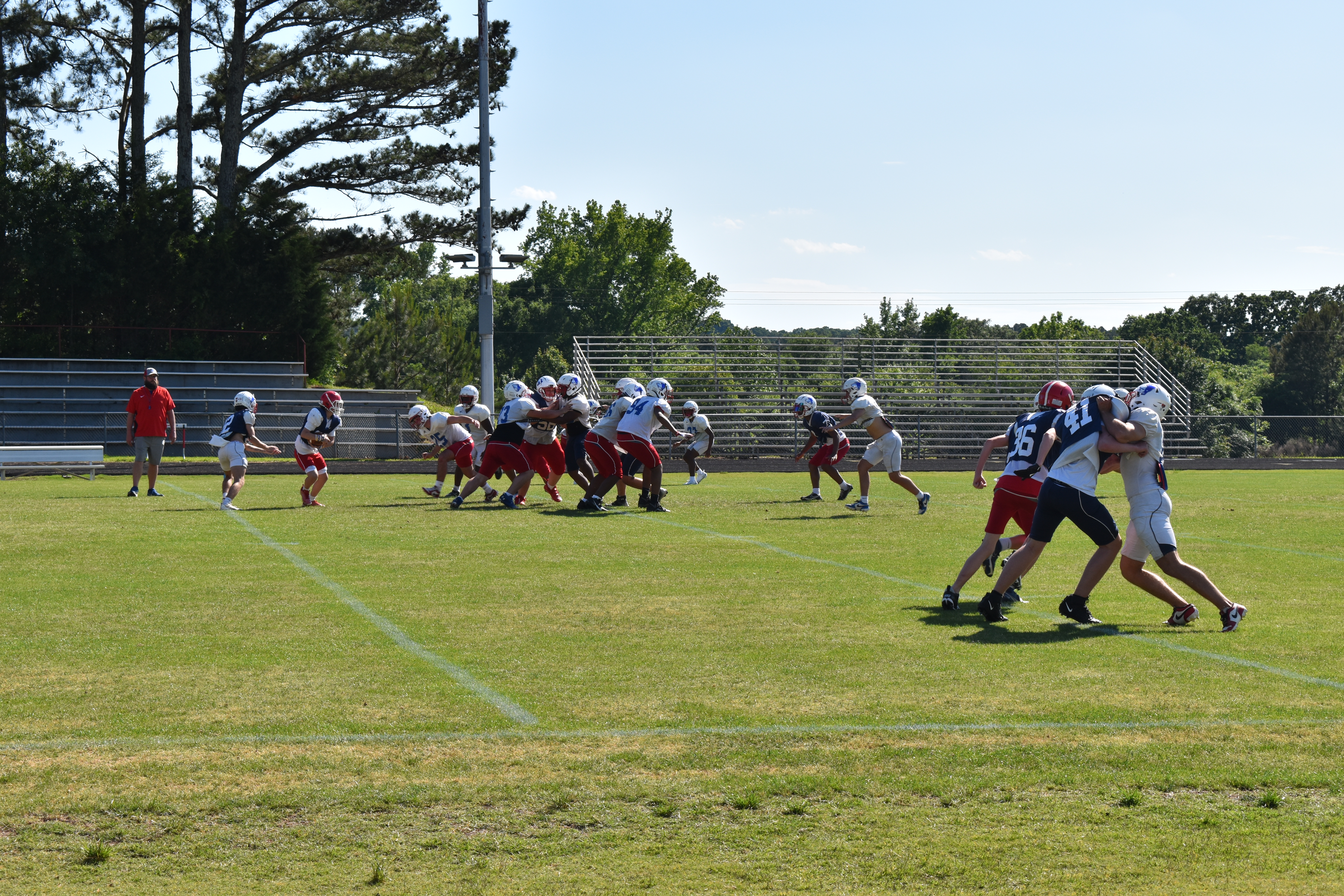 OCHS football players go through spring drills at Patriot Stadium on Tuesday. Head coach Mike Holland expects to see improvement from several returning players this year. (Photo/Emma Greene)