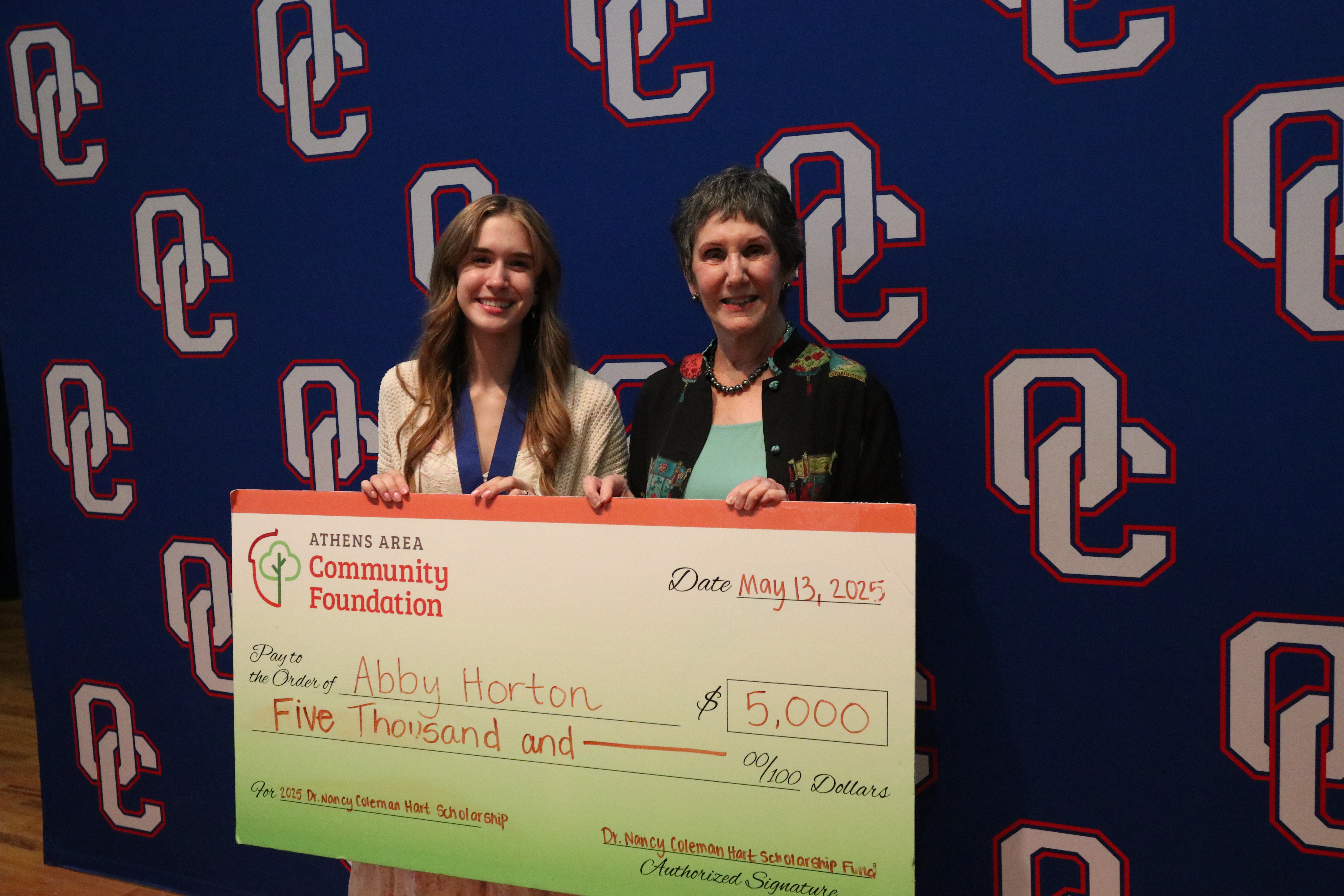 Abby Horton and Nancy Coleman Hart hold a check signifying that Horton was awarded the inaugural $5,000 Dr. Nancy Coleman Hart scholarship that honors Hart, a former OCES principal and curriculum director, and the late Bob Hart, her husband who died in February. (Photo/Anna Izquierdo)