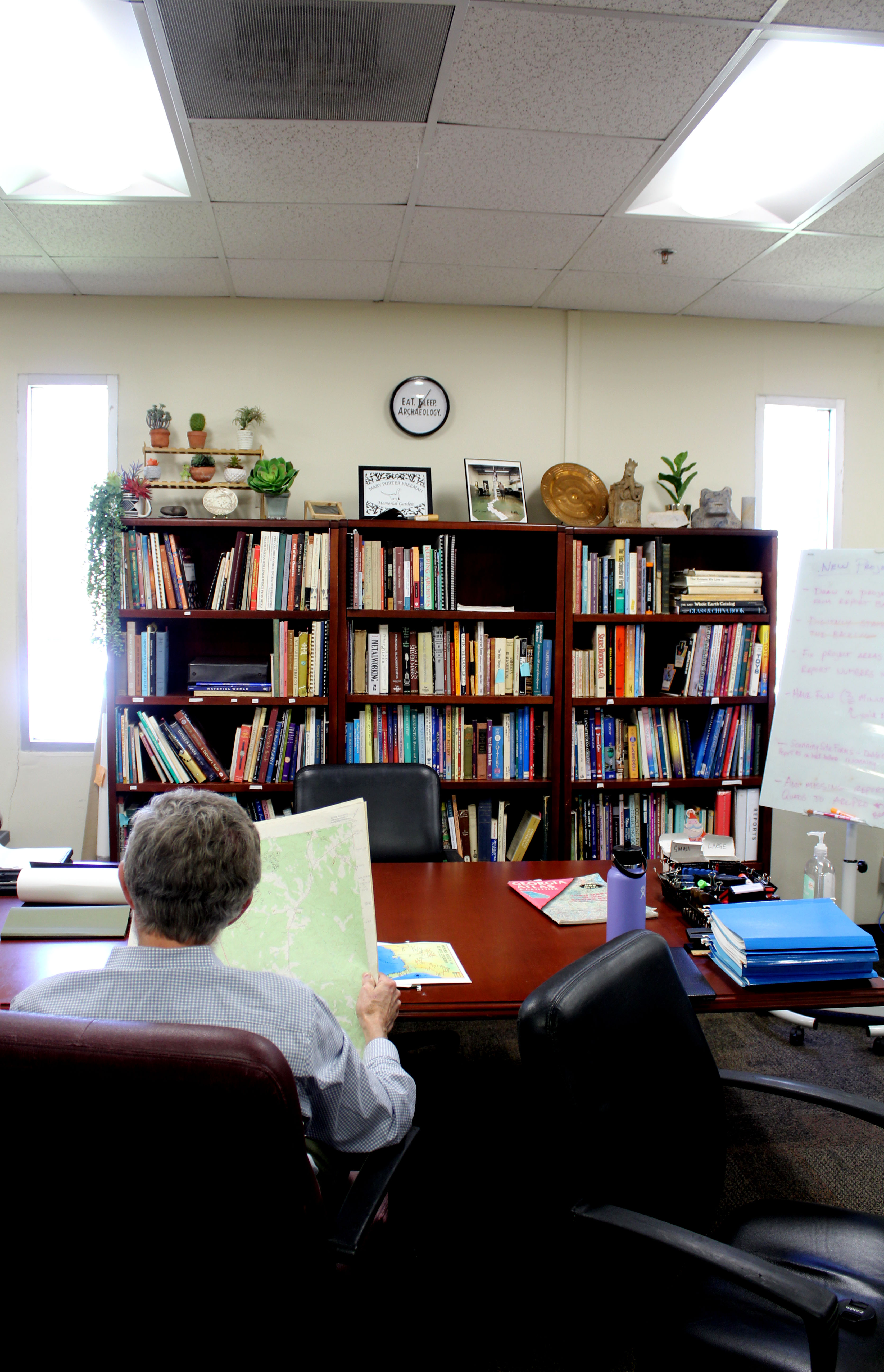 Tom Gresham holds one of the maps detailing Native American sites in Oglethorpe County at UGA’s Archaeological Laboratory this spring. He said the Native Americans in the region lived on farmsteads, which include houses for the extended family. (Photo/Emily Slepsky)