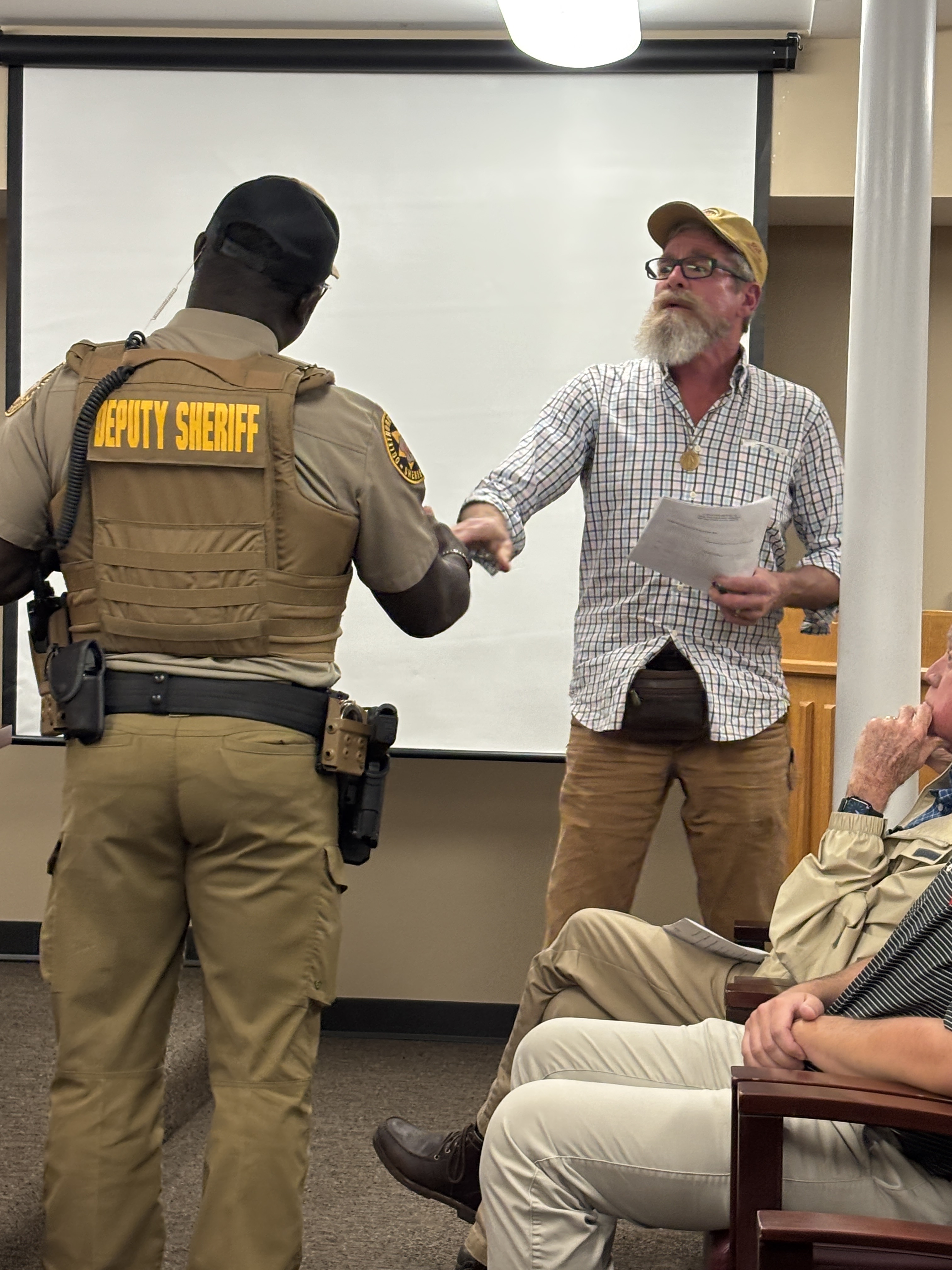 Oglethorpe County deputy Jason Metoyer asks Brad Johns to cede the floor during the public comment portion of the Board of Commissioners meeting on Monday. Johns surpassed his allotted three minutes by several minutes. (Photo/Andy Johnston)