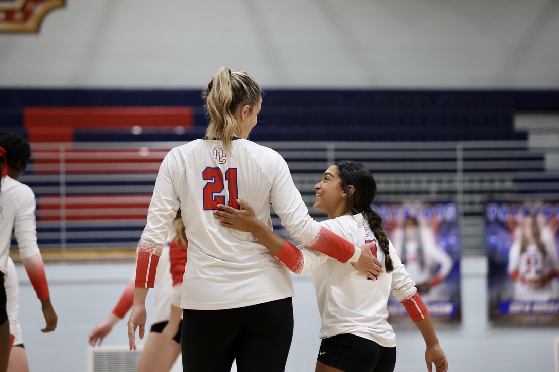 Oglethorpe County libero Aryana Knight (right), who is 4-foot-9, shows her height difference with teammate Elizabeth Cook, who is listed at 6 feet, during a match last fall. Knight is one of the Patriots’ top defenders. (Photo/Ty Johnston)